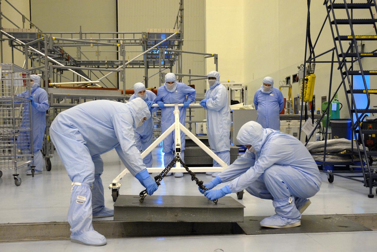 CAPE CANAVERAL, Fla. – In the Payload Hazardous Servicing Facility at NASA's Kennedy Space Center, workers prepare the floor in order to move flight support system (FSS) access scaffolding. The scaffolding will be used to prepare the Hubble Space Telescope, or HST, carriers for the STS-125 servicing mission 4. The FSS will berth, secure and furnish power to Hubble and also contains the soft capture mechanism to be attached to the telescope. Upon completion of STS-125, the Hubble will provide even deeper and more detailed views of the Universe. The STS-125 mission will be the final space shuttle mission to the Hubble Space Telescope. Photo credit: NASA/Jack Pfaller