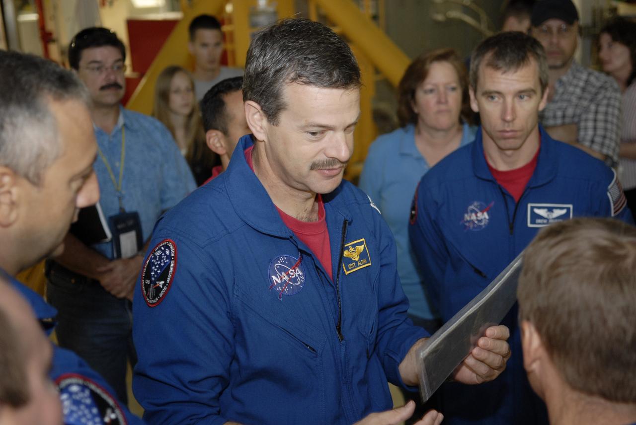 CAPE CANAVERAL, Fla. – In the Orbiter Processing Facility at NASA's Kennedy Space Center, STS-125 Commander Scott Altman looks at a piece of equipment.  On either side are Mission Specialists Mike Massimino (left) and Andrew Feustel. Crew members are at Kennedy for a crew equipment interface test, which provides hands-on experience with hardware and equipment for their mission. Atlantis is targeted to launch on the STS-125 Hubble Servicing Mission 4 on Oct. 8.  Photo credit: NASA/Kim Shiflett