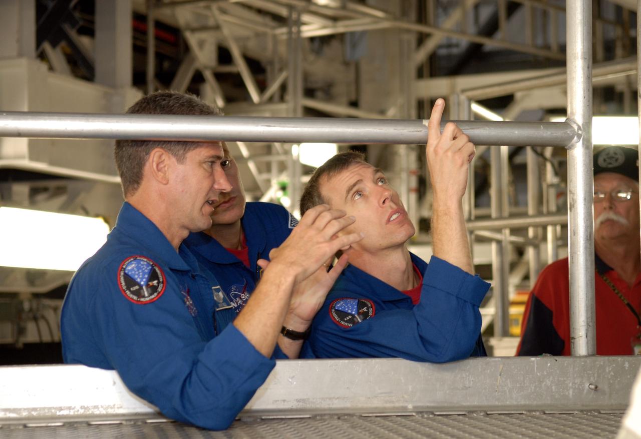 CAPE CANAVERAL, Fla. – In the Orbiter Processing Facility at NASA's Kennedy Space Center, STS-125 Mission Specialists Michael Good, Mike Massimino and Andrew Feustel discuss the tiles they are looking at on the underside of space shuttle Atlantis.  Crew members are at Kennedy for a crew equipment interface test, which provides hands-on experience with hardware and equipment for their mission.  Atlantis is targeted to launch on the STS-125 Hubble Servicing Mission 4 on Oct. 8.  Photo credit: NASA/Kim Shiflett