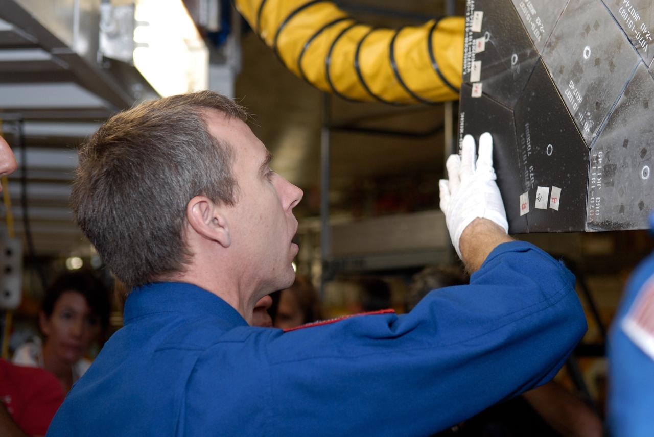 CAPE CANAVERAL, Fla. – In the Orbiter Processing Facility at NASA's Kennedy Space Center, STS-125 Mission Specialist Andrew Feustel touches the thermal protection system tiles on space shuttle Atlantis with a gloved hand during a crew equipment interface test. The CEIT provides hands-on experience with hardware and equipment for their mission.  Atlantis is targeted to launch on the STS-125 Hubble Servicing Mission 4 on Oct. 8.  Photo credit: NASA/Kim Shiflett