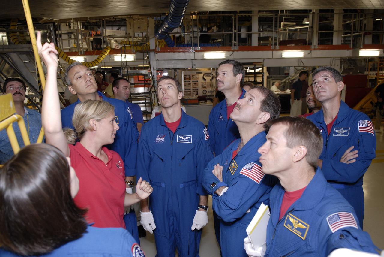 CAPE CANAVERAL, Fla. – In the Orbiter Processing Facility at NASA's Kennedy Space Center, a technician (hand raised) discusses details about space shuttle Atlantis with crew members for the STS-125 Hubble Servicing Mission.  From left, the crew members are Mission Specialists Megan McArthur, Mike Massimino and Andrew Feustel, Commander Scott Altman, Mission Specialists John Grunsfeld and Mike Good, and Pilot Gregory C. Johnson (foreground).  The crew is at Kennedy for a crew equipment interface test, which provides hands-on experience with hardware and equipment for the mission. Atlantis is targeted to launch on the STS-125 Hubble Servicing Mission 4 on Oct. 8.  Photo credit: NASA/Kim Shiflett