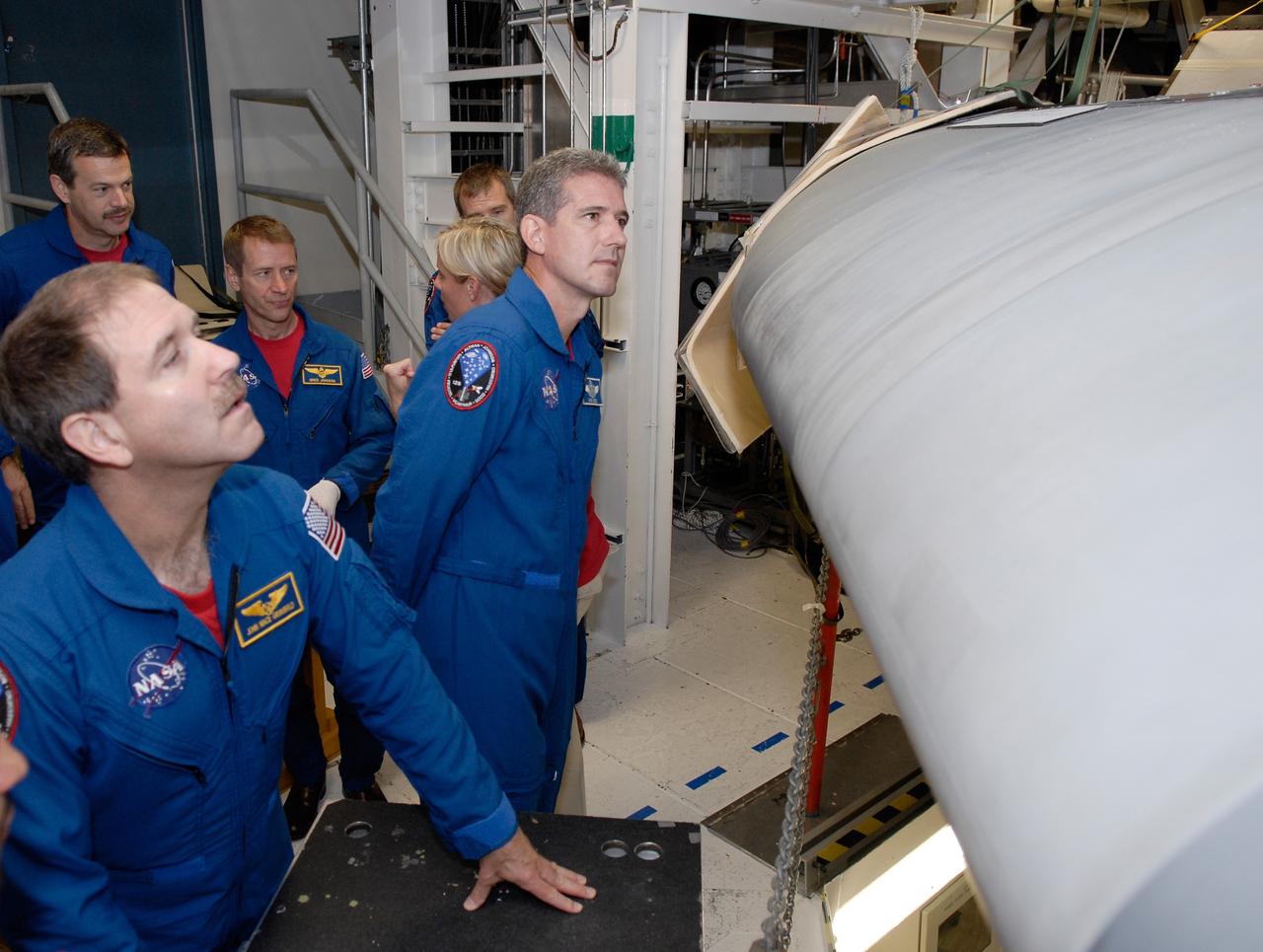 CAPE CANAVERAL, Fla. – In the Orbiter Processing Facility at NASA's Kennedy Space Center, STS-125 Mission Specialists John Grunsfeld (left) and Mike Good take a close look at the wing on space shuttle Atlantis. Behind them, talking to a technician, are Commander Scott Altman (left), Pilot Gregory C. Johnson (center) and Mission Specialist Andrew Feustel. The crew is at Kennedy for a crew equipment interface test, which provides hands-on experience with hardware and equipment for the mission. Atlantis is targeted to launch on the STS-125 Hubble Servicing Mission 4 on Oct. 8. Photo credit: NASA/Kim Shiflett