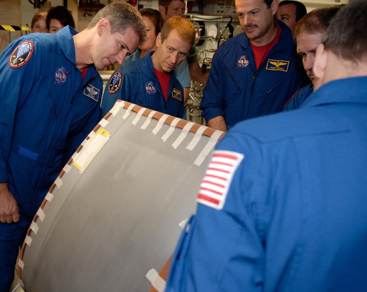CAPE CANAVERAL, Fla. – In the Orbiter Processing Facility at NASA's Kennedy Space Center, STS-125 Mission Specialist Mike Good, Pilot Gregory C. Johnson, Commander Scott Altman and Mission Specialist John Grunsfeld look at a reinforced carbon-carbon panel. The RCC panels are part of the thermal protection system used on space shuttles. The crew is at Kennedy for a crew equipment interface test, which provides hands-on experience with hardware and equipment for the mission. Atlantis is targeted to launch on the STS-125 Hubble Servicing Mission 4 on Oct. 8. Photo credit: NASA/Kim Shiflett