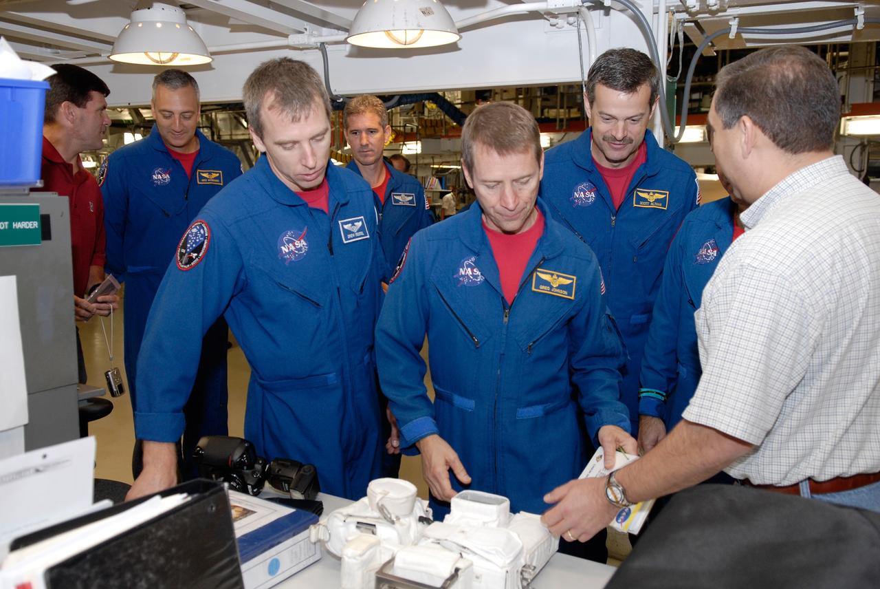CAPE CANAVERAL, Fla. –  In the Orbiter Processing Facility at NASA's Kennedy Space Center, STS-125 crew members look at cameras they will use on the mission.  From left are Mission Specialists Mike Massimino, Andrew Feustel and Mike Good, Pilot Gregory C. Johnson and Commander Scott Altman.  The crew is at Kennedy for a crew equipment interface test, which provides hands-on experience with hardware and equipment for the mission. Atlantis is targeted to launch on the STS-125 Hubble Servicing Mission 4 on Oct. 8.  Photo credit: NASA/Kim Shiflett