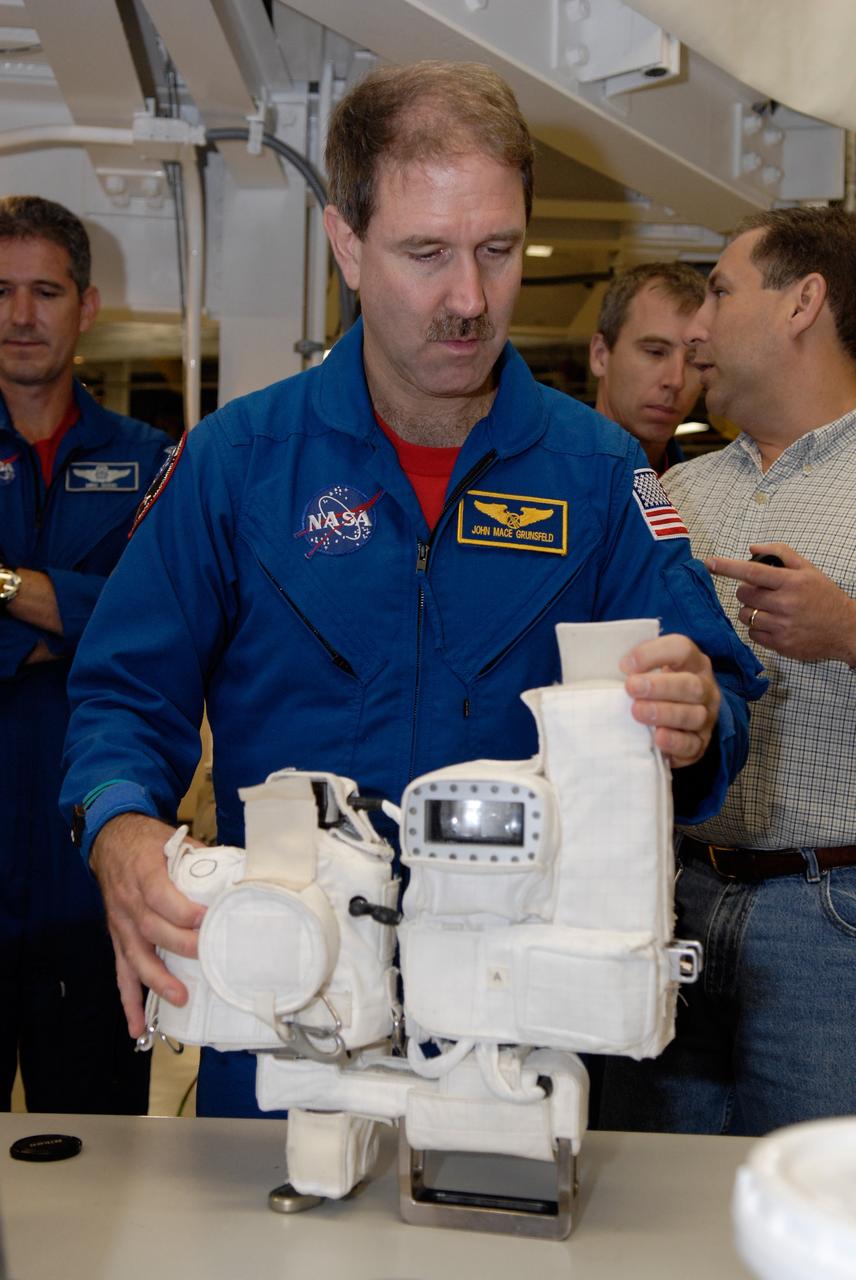 CAPE CANAVERAL, Fla. – In the Orbiter Processing Facility at NASA's Kennedy Space Center, STS-125 Mission Specialist John Grunsfeld takes hold of one of the cameras to be used on the mission. Behind him are Mission Specialists Mike Good (left) and Andrew Feustel (right). The crew is at Kennedy for a crew equipment interface test, which provides hands-on experience with hardware and equipment for the mission. Atlantis is targeted to launch on the STS-125 Hubble Servicing Mission 4 on Oct. 8. Photo credit: NASA/Kim Shiflett
