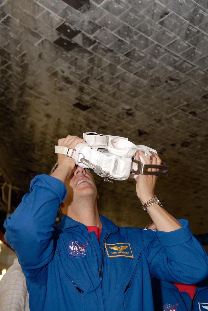CAPE CANAVERAL, Fla. – In the Orbiter Processing Facility at NASA's Kennedy Space Center, STS-125 Mission Specialist Mike Massimino practices using one of the cameras for the mission. The crew is at Kennedy for a crew equipment interface test, which provides hands-on experience with hardware and equipment on the mission. Atlantis is targeted to launch on the STS-125 Hubble Servicing Mission 4 on Oct. 8. Photo credit: NASA/Kim Shiflett