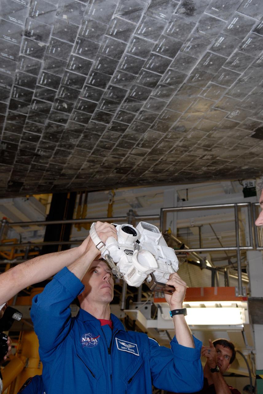 CAPE CANAVERAL, Fla. – In the Orbiter Processing Facility at NASA's Kennedy Space Center, STS-125 Mission Specialist Andrew Feustel practices using one of the cameras for the mission. The crew is at Kennedy for a crew equipment interface test, which provides hands-on experience with hardware and equipment on the mission. Atlantis is targeted to launch on the STS-125 Hubble Servicing Mission 4 on Oct. 8. Photo credit: NASA/Kim Shiflett