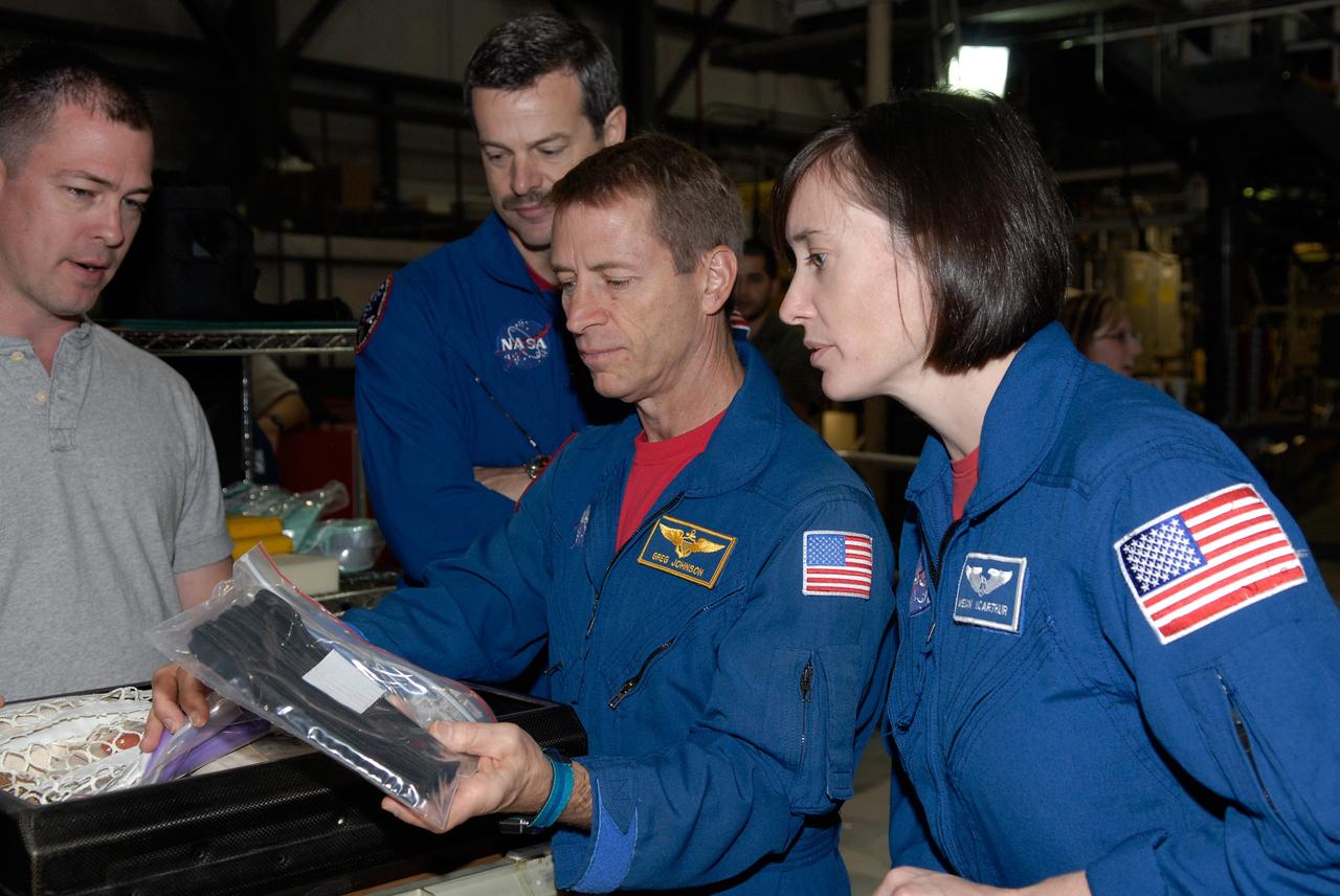 CAPE CANAVERAL, Fla. –  In the Orbiter Processing Facility at NASA's Kennedy Space Center, STS-125 crew members look at some of the equipment that will be on their mission.  From right are Mission Specialist Megan McArthur, Pilot Gregory C. Johnson and Commander Scott Altman. The crew is at Kennedy for a crew equipment interface test, which provides hands-on experience with hardware and equipment for the mission. Atlantis is targeted to launch on the STS-125 Hubble Servicing Mission 4 on Oct. 8.  Photo credit: NASA/Kim Shiflett