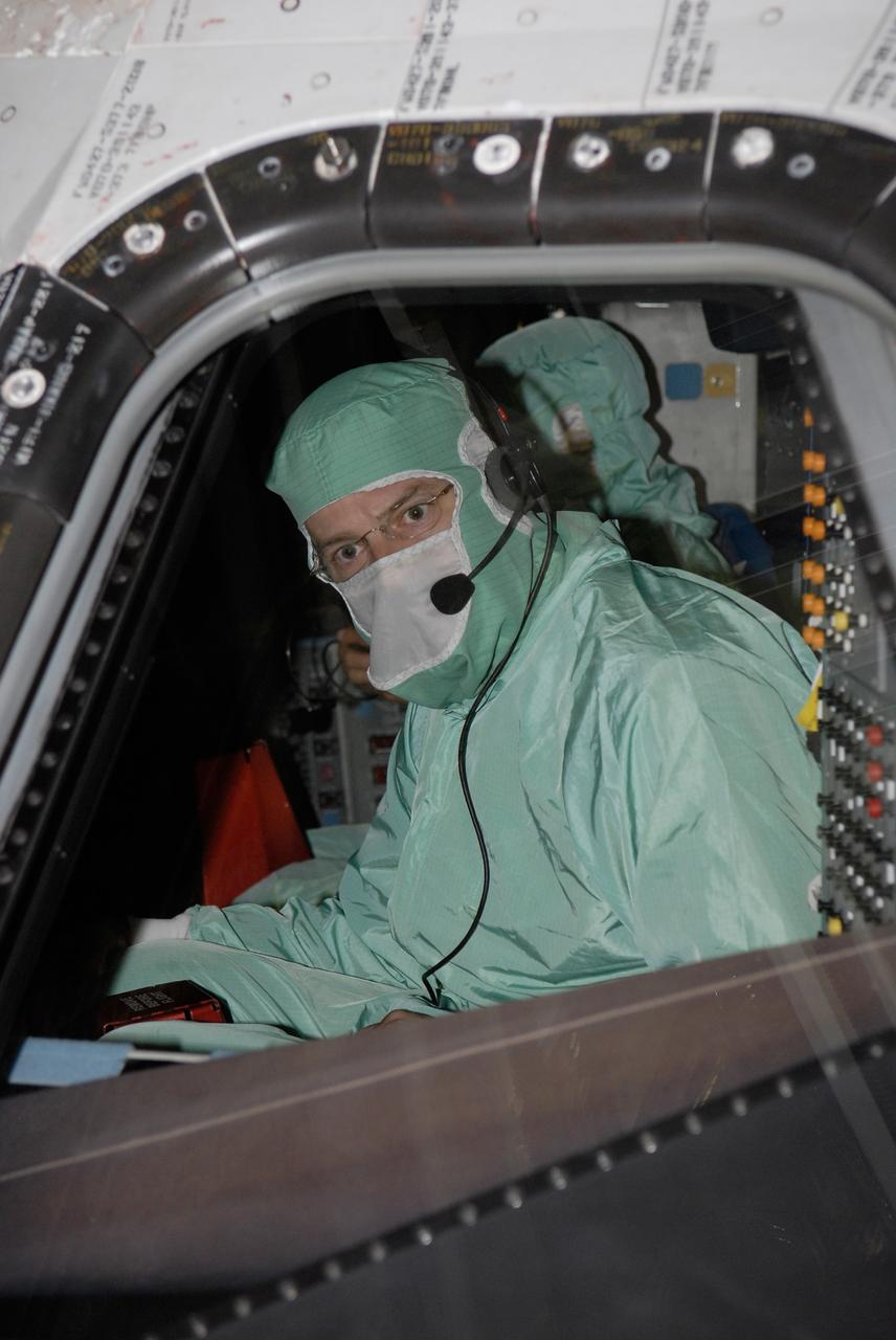 CAPE CANAVERAL, Fla. – In the Orbiter Processing Facility at NASA's Kennedy Space Center, STS-125 Commander Scott Altman examines the cockpit window on space shuttle Atlantis. The inspection is part of the crew equipment interface test, which provides hands-on experience with hardware and equipment for the mission. Atlantis is targeted to launch Oct. 8 on the STS-125 mission to service the Hubble Space Telescope. The mission crew will perform history-making, on-orbit “surgery” on two important science instruments aboard the telescope. After capturing the telescope, two teams of spacewalking astronauts will perform the repairs during five planned spacewalks. Photo credit: NASA/Kim Shiflett
