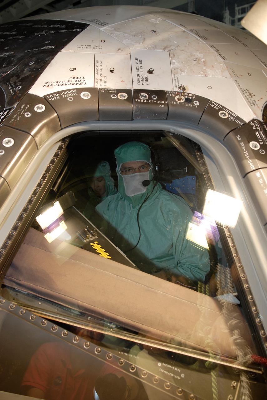 CAPE CANAVERAL, Fla. – In the Orbiter Processing Facility at NASA's Kennedy Space Center, STS-125 Commander Scott Altman examines the cockpit window on space shuttle Atlantis, checking for sharp edges. The inspection is part of the crew equipment interface test, which provides hands-on experience with hardware and equipment for the mission. Atlantis is targeted to launch Oct. 8 on the STS-125 mission to service the Hubble Space Telescope. The mission crew will perform history-making, on-orbit “surgery” on two important science instruments aboard the telescope. After capturing the telescope, two teams of spacewalking astronauts will perform the repairs during five planned spacewalks. Photo credit: NASA/Kim Shiflett