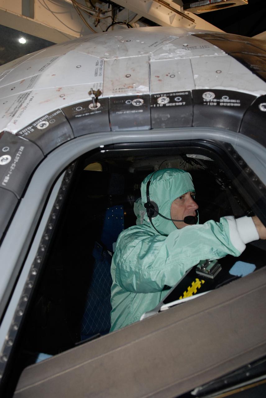 CAPE CANAVERAL, Fla. – In the Orbiter Processing Facility at NASA's Kennedy Space Center, STS-125 Pilot Gregory C. Johnson examines the cockpit window on space shuttle Atlantis, checking for sharp edges. The inspection is part of the crew equipment interface test, which provides hands-on experience with hardware and equipment for the mission. Atlantis is targeted to launch Oct. 8 on the STS-125 mission to service the Hubble Space Telescope. The mission crew will perform history-making, on-orbit “surgery” on two important science instruments aboard the telescope. After capturing the telescope, two teams of spacewalking astronauts will perform the repairs during five planned spacewalks. Photo credit: NASA/Kim Shiflett