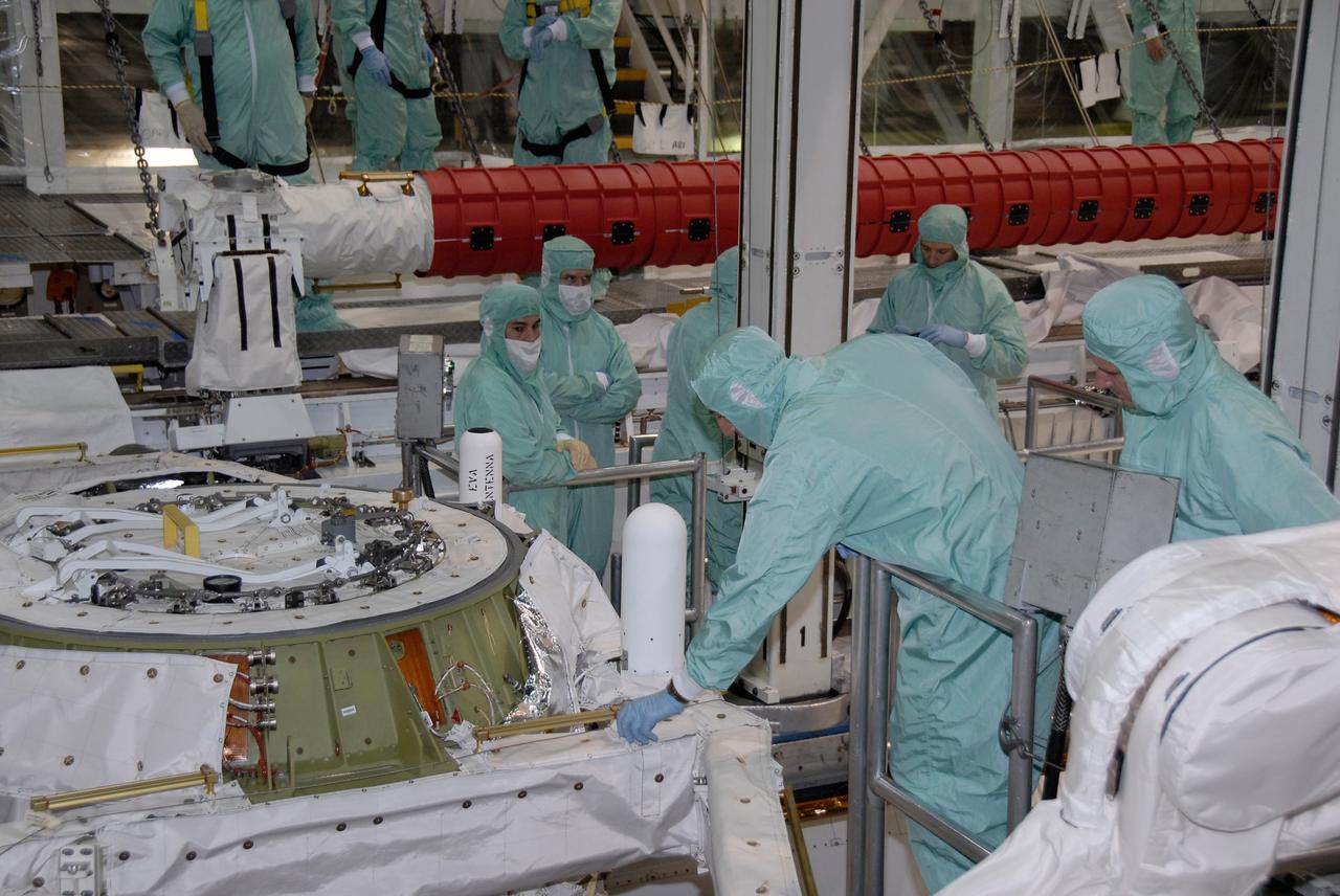 CAPE CANAVERAL, Fla. –  In the Orbiter Processing Facility at NASA's Kennedy Space Center, STS-125 crew members are lowered into space shuttle Atlantis' payload bay for a close look at the hardware.  Equipment familiarization is part of the crew equipment interface test, which provides hands-on experience with hardware and equipment for the mission.  Crew members are Commander Scott Altman, Pilot Gregory C. Johnson, and Mission Specialists Michael Good, Megan McArthur, John Grunsfeld, Mike Massimino (reaching toward the airlock) and Andrew Feustel. Atlantis is targeted to launch Oct. 8 on the STS-125 mission to service the Hubble Space Telescope. The mission crew will perform history-making, on-orbit “surgery” on two important science instruments aboard the telescope.  After capturing the telescope, two teams of spacewalking astronauts will perform the repairs during five planned spacewalks.    Photo credit: NASA/Kim Shiflett