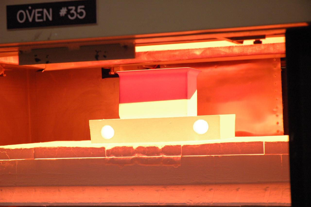 CAPE CANAVERAL, Fla. – In the tile shop at NASA's Kennedy Space Center, a Boeing Replacement Insulation 18, or BRI-18, tile bakes in a 2,200-degree oven to cure the ceramic coating. The baking is part of the process to prepare the tiles for installation on space shuttles. BRI-18 is the strongest material used for thermal insulation on the orbiters and, when coated to produce toughened unipiece fibrous insulation, provides a tile with extremely high-impact resistance. It is replacing other tiles on areas of the vehicle where impact risk is high, such as the landing gear doors, the wing leading edge and the external tank doors. Photo credit: NASA/Jim Grossmann