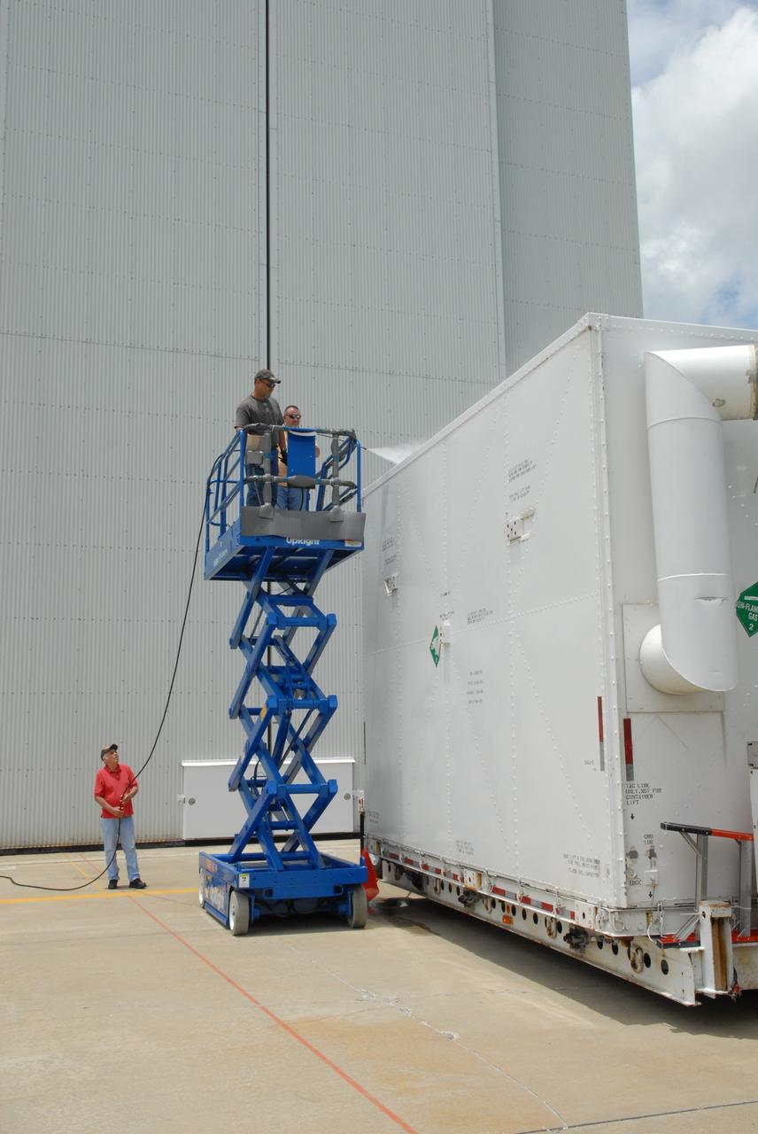 CAPE CANAVERAL, Fla. – At the Canister Rotation Facility at NASA's Kennedy Space Center, workers steam clean the shipping containers holding the first major flight hardware for space shuttle Atlantis' STS-125 mission to NASA's Hubble Space Telescope. The containers will next be moved to the airlock in the Payload Hazardous Servicing facility where the hardware will be prepared for its targeted October launch. The payload carriers will be prepared for the integration of telescope science instruments, both internal and external replacement components, as well as the flight support equipment to be used by the astronauts during the servicing mission. The three payload carriers or pallets are the Flight Support System, the Super Lightweight Interchangeable Carrier and the Orbital Replacement Unit Carrier. At the end of July, a fourth and final carrier, the Multi-Use Lightweight Equipment carrier will join the others in the Payload Hazardous Servicing Facility where the Hubble payload is being prepared for launch. Photo credit: NASA/Jack Pfaller