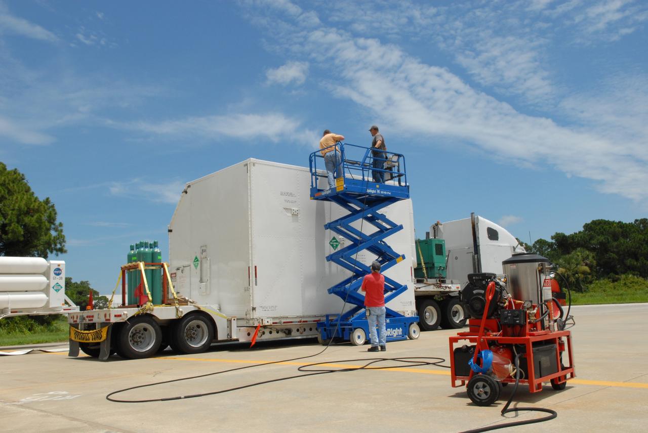 CAPE CANAVERAL, Fla. – At the Canister Rotation Facility at NASA's Kennedy Space Center, workers steam clean the shipping containers holding the first major flight hardware for space shuttle Atlantis' STS-125 mission to NASA's Hubble Space Telescope. The containers will next be moved to the airlock in the Payload Hazardous Servicing facility where the hardware will be prepared for its targeted October launch. The payload carriers will be prepared for the integration of telescope science instruments, both internal and external replacement components, as well as the flight support equipment to be used by the astronauts during the servicing mission. The three payload carriers or pallets are the Flight Support System, the Super Lightweight Interchangeable Carrier and the Orbital Replacement Unit Carrier. At the end of July, a fourth and final carrier, the Multi-Use Lightweight Equipment carrier will join the others in the Payload Hazardous Servicing Facility where the Hubble payload is being prepared for launch. Photo credit: NASA/Jack Pfaller