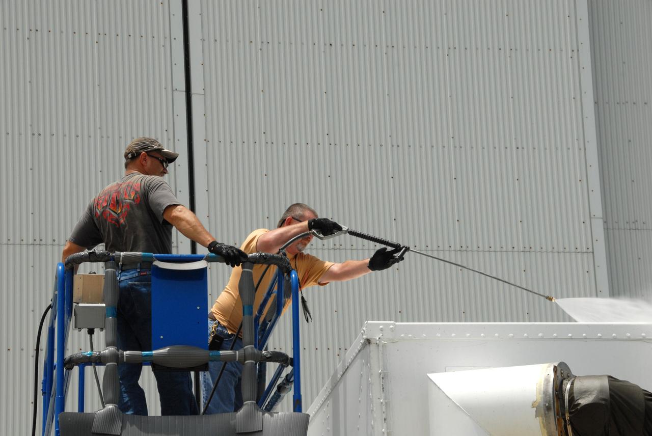 CAPE CANAVERAL, Fla. – At the Canister Rotation Facility at NASA's Kennedy Space Center, workers steam clean the shipping containers holding the first major flight hardware for space shuttle Atlantis' STS-125 mission to NASA's Hubble Space Telescope. The containers will next be moved to the airlock in the Payload Hazardous Servicing facility where the hardware will be prepared for its targeted October launch. The payload carriers will be prepared for the integration of telescope science instruments, both internal and external replacement components, as well as the flight support equipment to be used by the astronauts during the servicing mission. The three payload carriers or pallets are the Flight Support System, the Super Lightweight Interchangeable Carrier and the Orbital Replacement Unit Carrier. At the end of July, a fourth and final carrier, the Multi-Use Lightweight Equipment carrier will join the others in the Payload Hazardous Servicing Facility where the Hubble payload is being prepared for launch. Photo credit: NASA/Jack Pfaller