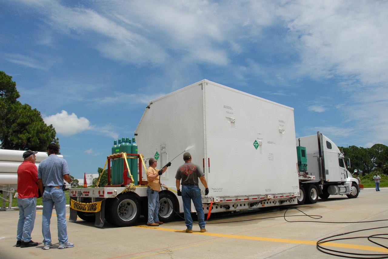 CAPE CANAVERAL, Fla. –  At the Canister Rotation Facility at NASA's Kennedy Space Center, workers steam clean the shipping containers holding the first major flight hardware for space shuttle Atlantis' STS-125 mission to NASA's Hubble Space Telescope.  The containers will next be moved to the airlock in the Payload Hazardous Servicing facility where the hardware will be prepared for its targeted October launch.  The payload carriers will be prepared for the integration of telescope science instruments, both internal and external replacement components, as well as the flight support equipment to be used by the astronauts during the servicing mission.  The three payload carriers or pallets are the Flight Support System, the Super Lightweight Interchangeable Carrier and the Orbital Replacement Unit Carrier.  At the end of July, a fourth and final carrier, the Multi-Use Lightweight Equipment carrier will join the others in the Payload Hazardous Servicing Facility where the Hubble payload is being prepared for launch. Photo credit: NASA/Jack Pfaller