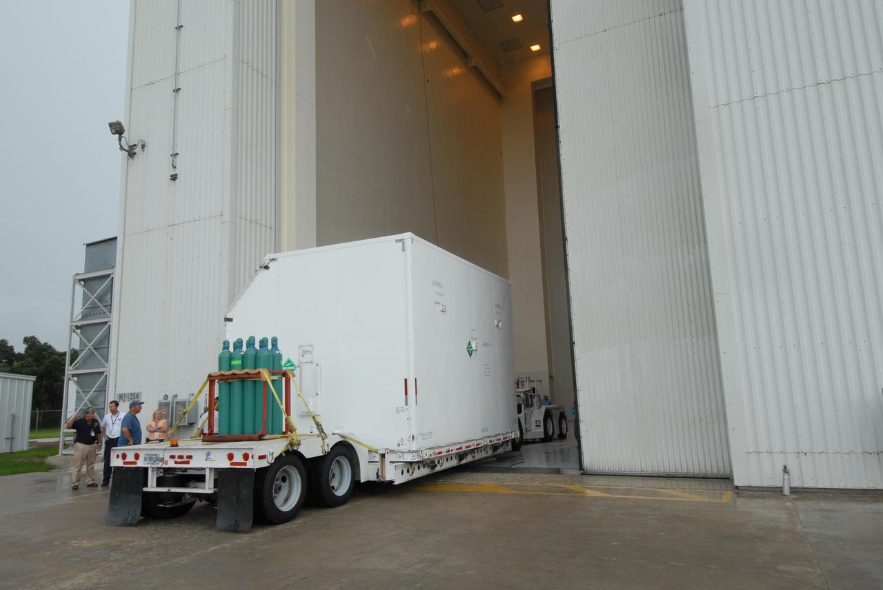 CAPE CANAVERAL, Fla. – A container with flight hardware for space shuttle Atlantis' STS-125 mission to NASA's Hubble Space Telescope is moved through the open door into the airlock in the Payload Hazardous Servicing Facility at NASA's Kennedy Space Center. In the facility, the hardware will be prepared for its targeted October launch. The payload carriers will be prepared for the integration of telescope science instruments, both internal and external replacement components, as well as the flight support equipment to be used by the astronauts during the servicing mission. The three payload carriers or pallets are the Flight Support System, the Super Lightweight Interchangeable Carrier and the Orbital Replacement Unit Carrier. At the end of July, a fourth and final carrier, the Multi-Use Lightweight Equipment carrier will join the others in the Payload Hazardous Servicing Facility where the Hubble payload is being prepared for launch. Photo credit: NASA/Jack Pfaller