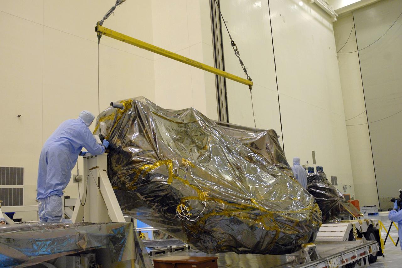 CAPE CANAVERAL, Fla. –  In the Payload Hazardous Servicing Facility at NASA's Kennedy Space Center, a worker checks the position of the ground support equipment for the STS-125 Hubble Servicing Mission as it is lifted off the transporter.  The GSE are carriers, or pallets, that will hold equipment in space shuttle Atlantis’ payload bay.  This carrier will be moved to a work stand. The carriers will be prepared for the integration of telescope science instruments, both internal and external replacement components, as well as the flight support equipment to be used by the astronauts during the servicing mission.  The three payload carriers or pallets are the Flight Support System, the Super Lightweight Interchangeable Carrier and the Orbital Replacement Unit Carrier.  At the end of July, a fourth and final carrier, the Multi-Use Lightweight Equipment carrier will join the others in the Payload Hazardous Servicing Facility where the Hubble payload is being prepared for launch. Photo credit: NASA/Cory Huston