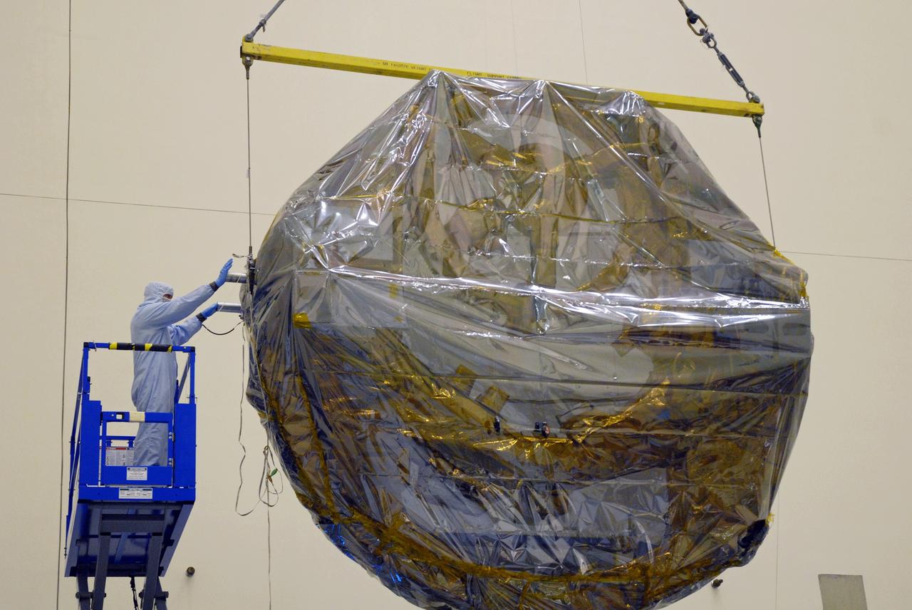 CAPE CANAVERAL, Fla. –  In the Payload Hazardous Servicing Facility at NASA's Kennedy Space Center, an overhead crane lifts the newly arrived ground support equipment for the STS-125 Hubble Servicing Mission off its transporter.  The GSE are carriers, or pallets, that will hold equipment in space shuttle Atlantis’ payload bay.  Under the protective covering of the carrier can be seen the soft capture mechanism. This carrier will be moved to a work stand. The carriers will be prepared for the integration of telescope science instruments, both internal and external replacement components, as well as the flight support equipment to be used by the astronauts during the servicing mission.  The three payload carriers or pallets are the Flight Support System, the Super Lightweight Interchangeable Carrier and the Orbital Replacement Unit Carrier.  At the end of July, a fourth and final carrier, the Multi-Use Lightweight Equipment carrier will join the others in the Payload Hazardous Servicing Facility where the Hubble payload is being prepared for launch. Photo credit: NASA/Cory Huston