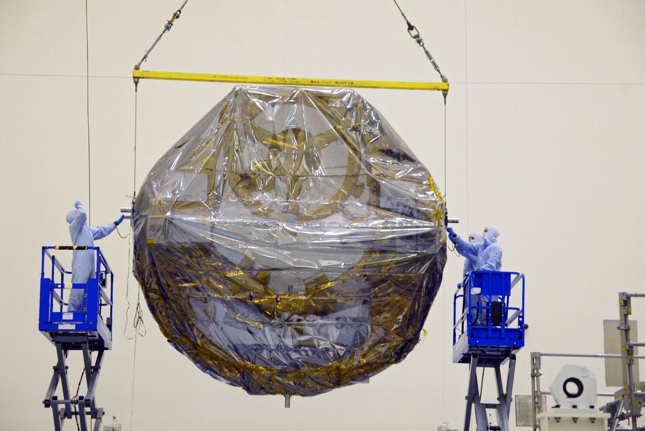 CAPE CANAVERAL, Fla. –  In the Payload Hazardous Servicing Facility at NASA's Kennedy Space Center, workers check the attachments on the ground support equipment for the STS-125 Hubble Servicing Mission as it is transferred to a work stand.  The GSE are carriers, or pallets, that will hold equipment in space shuttle Atlantis’ payload bay.  Under the protective covering of the carrier can be seen the soft capture mechanism. The carriers will be prepared for the integration of telescope science instruments, both internal and external replacement components, as well as the flight support equipment to be used by the astronauts during the servicing mission.  The three payload carriers or pallets are the Flight Support System, the Super Lightweight Interchangeable Carrier and the Orbital Replacement Unit Carrier.  At the end of July, a fourth and final carrier, the Multi-Use Lightweight Equipment carrier will join the others in the Payload Hazardous Servicing Facility where the Hubble payload is being prepared for launch. Photo credit: NASA/Cory Huston