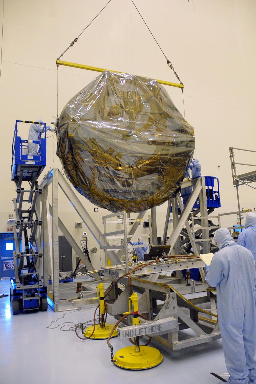 CAPE CANAVERAL, Fla. –  In the Payload Hazardous Servicing Facility at NASA's Kennedy Space Center, the overhead crane lowers the newly arrived ground support equipment for the STS-125 Hubble Servicing Mission toward a thermal vacuum fixture.  The GSE are carriers, or pallets, that will hold equipment in space shuttle Atlantis’ payload bay.  Under the protective covering of the carrier can be seen the soft capture mechanism.  The carriers will be prepared for the integration of telescope science instruments, both internal and external replacement components, as well as the flight support equipment to be used by the astronauts during the servicing mission.  The three payload carriers or pallets are the Flight Support System, the Super Lightweight Interchangeable Carrier and the Orbital Replacement Unit Carrier.  At the end of July, a fourth and final carrier, the Multi-Use Lightweight Equipment carrier will join the others in the Payload Hazardous Servicing Facility where the Hubble payload is being prepared for launch. Photo credit: NASA/Cory Huston