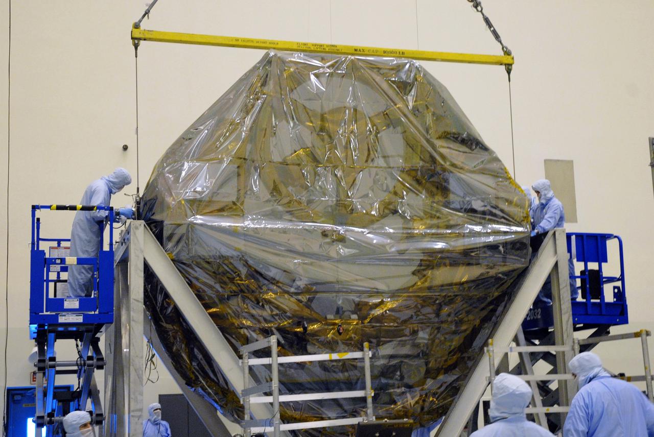 CAPE CANAVERAL, Fla. –   In the Payload Hazardous Servicing Facility at NASA's Kennedy Space Center, the overhead crane lowers the ground support equipment for the STS-125 Hubble Servicing Mission into a thermal vacuum fixture.  The GSE are carriers, or pallets, that will hold equipment in space shuttle Atlantis’ payload bay.  Under the protective covering of the carrier can be seen the soft capture mechanism. The carriers will be prepared for the integration of telescope science instruments, both internal and external replacement components, as well as the flight support equipment to be used by the astronauts during the servicing mission.  The three payload carriers or pallets are the Flight Support System, the Super Lightweight Interchangeable Carrier and the Orbital Replacement Unit Carrier.  At the end of July, a fourth and final carrier, the Multi-Use Lightweight Equipment carrier will join the others in the Payload Hazardous Servicing Facility where the Hubble payload is being prepared for launch. Photo credit: NASA/Cory Huston