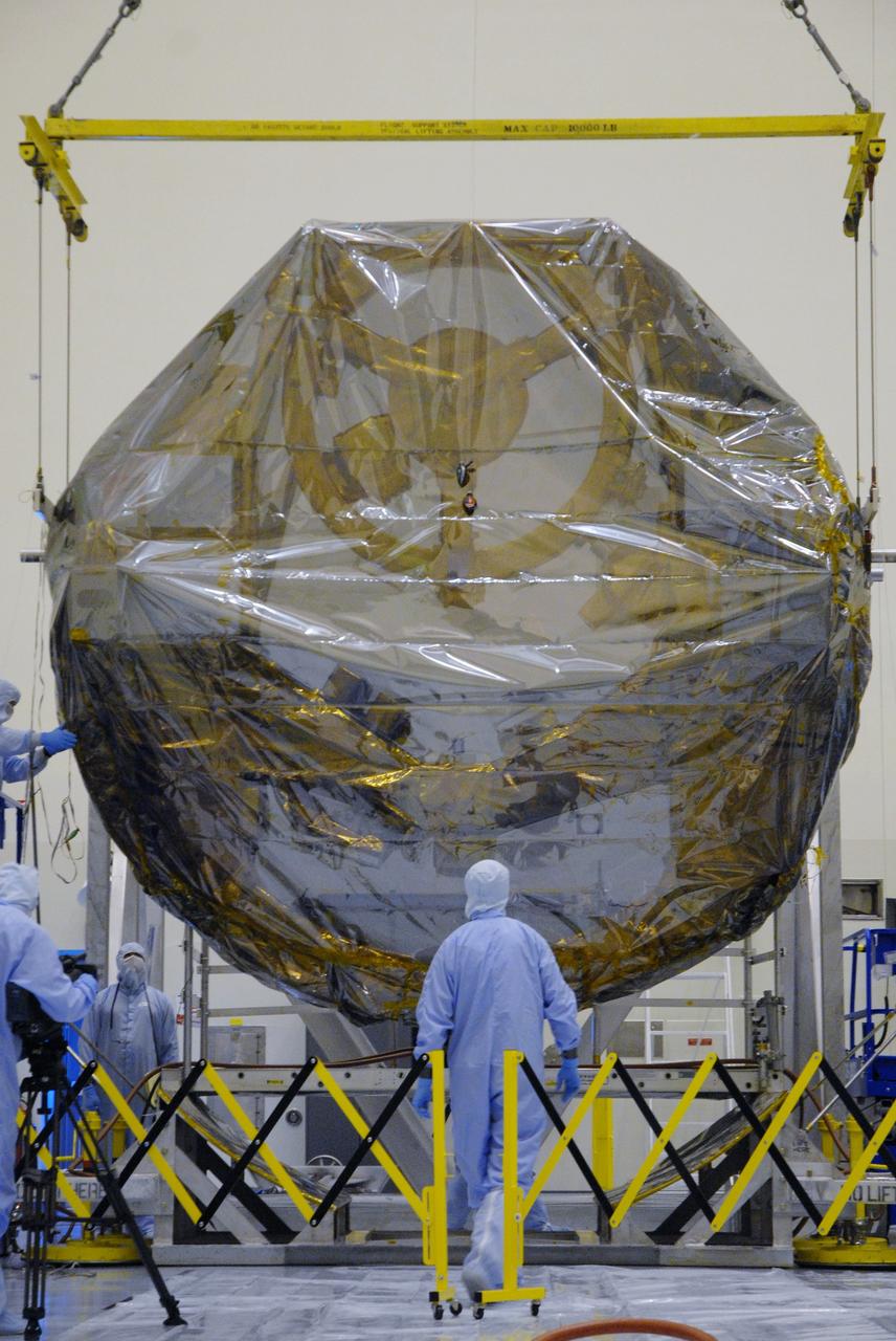 CAPE CANAVERAL, Fla. –  In the Payload Hazardous Servicing Facility at NASA's Kennedy Space Center, the overhead crane lowers the ground support equipment for the STS-125 Hubble Servicing Mission toward a work stand. The GSE are carriers, or pallets, that will hold equipment in space shuttle Atlantis’ payload bay.  Under the protective covering of the carrier can be seen the soft capture mechanism. The carriers will be prepared for the integration of telescope science instruments, both internal and external replacement components, as well as the flight support equipment to be used by the astronauts during the servicing mission.  The three payload carriers or pallets are the Flight Support System, the Super Lightweight Interchangeable Carrier and the Orbital Replacement Unit Carrier.  At the end of July, a fourth and final carrier, the Multi-Use Lightweight Equipment carrier will join the others in the Payload Hazardous Servicing Facility where the Hubble payload is being prepared for launch. Photo credit: NASA/Cory Huston