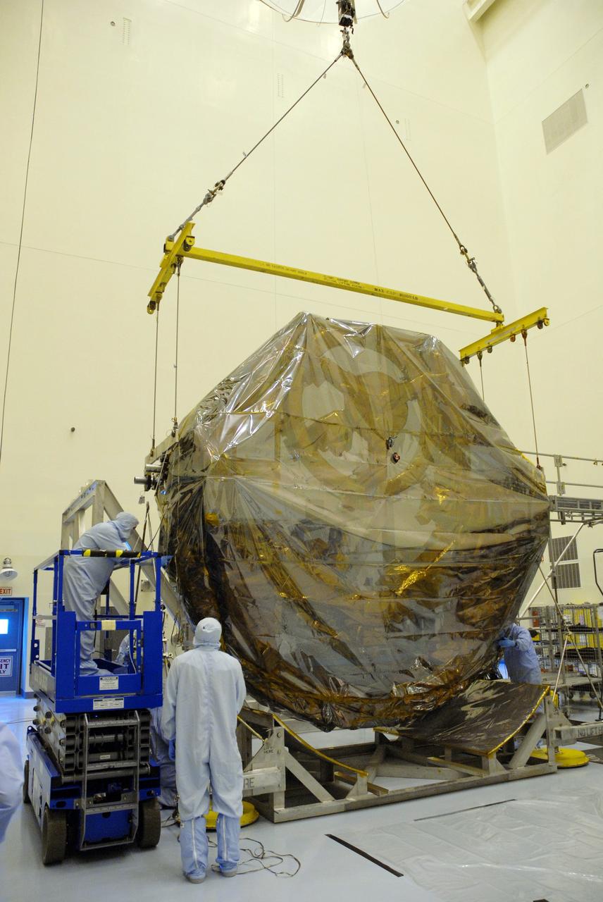 CAPE CANAVERAL, Fla. –  In the Payload Hazardous Servicing Facility at NASA's Kennedy Space Center, the overhead crane lowers the ground support equipment for the STS-125 Hubble Servicing Mission onto a work stand. The GSE are carriers, or pallets, that will hold equipment in space shuttle Atlantis’ payload bay.  Under the protective covering of the carrier can be seen the soft capture mechanism.  The carriers will be prepared for the integration of telescope science instruments, both internal and external replacement components, as well as the flight support equipment to be used by the astronauts during the servicing mission.  The three payload carriers or pallets are the Flight Support System, the Super Lightweight Interchangeable Carrier and the Orbital Replacement Unit Carrier.  At the end of July, a fourth and final carrier, the Multi-Use Lightweight Equipment carrier will join the others in the Payload Hazardous Servicing Facility where the Hubble payload is being prepared for launch. Photo credit: NASA/Cory Huston