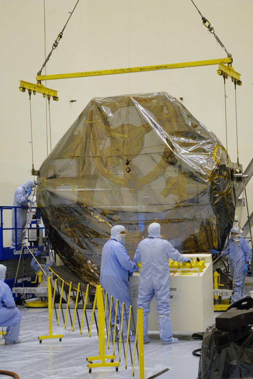 CAPE CANAVERAL, Fla. –  In the Payload Hazardous Servicing Facility at NASA's Kennedy Space Center, workers get ready to release the crane that lowered the ground support equipment for the STS-125 Hubble Servicing Mission onto a work stand. The GSE are carriers, or pallets, that will hold equipment in space shuttle Atlantis’ payload bay.  Under the protective covering of the carrier can be seen the soft capture mechanism.  The carriers will be prepared for the integration of telescope science instruments, both internal and external replacement components, as well as the flight support equipment to be used by the astronauts during the servicing mission.  The three payload carriers or pallets are the Flight Support System, the Super Lightweight Interchangeable Carrier and the Orbital Replacement Unit Carrier.  At the end of July, a fourth and final carrier, the Multi-Use Lightweight Equipment carrier will join the others in the Payload Hazardous Servicing Facility where the Hubble payload is being prepared for launch. Photo credit: NASA/Cory Huston