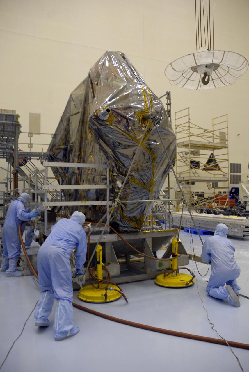 CAPE CANAVERAL, Fla. –   In the Payload Hazardous Servicing Facility, workers secure a carrier for the STS-125 Hubble Servicing Mission on the work stand.  The carrier and stand will be moved to scaffolding. The carrier, or pallet, will hold the flight support system equipment in space shuttle Atlantis’ payload bay. This and other carriers will be prepared for the integration of telescope science instruments, both internal and external replacement components, as well as the flight support equipment to be used by the astronauts during the servicing mission.  The three payload carriers are the Flight Support System, the Super Lightweight Interchangeable Carrier and the Orbital Replacement Unit Carrier.  At the end of July, a fourth and final carrier, the Multi-Use Lightweight Equipment carrier will join the others in the Payload Hazardous Servicing Facility where the Hubble payload is being prepared for the targeted Oct . 8 launch.  Photo credit: NASA/Jack Pfaller