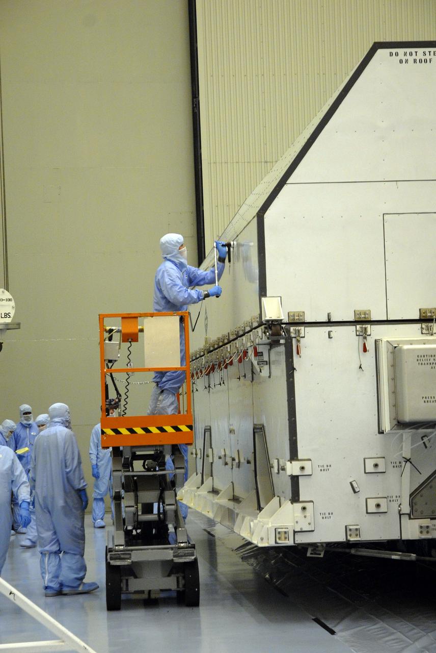 CAPE CANAVERAL, Fla. –  In the Payload Hazardous Servicing Facility at NASA's Kennedy Space Center, workers begin removing the shipping container cover over the hardware for space shuttle Atlantis' STS-125 mission to NASA's Hubble Space Telescope.  The container holds the Super Lightweight Interchangeable Carrier, or SLIC, and the Orbital Replacement Unit Carrier, or ORUC. Another payload carrier, the Flight Support System, has already been delivered  and the Multi-Use Lightweight Equipment carrier will be delivered in late July. The carriers will be prepared for the integration of telescope science instruments, both internal and external replacement components, as well as the flight support equipment to be used by the astronauts during the Hubble servicing mission, targeted for launch Oct. 8.  Photo credit: NASA/Jack Pfaller