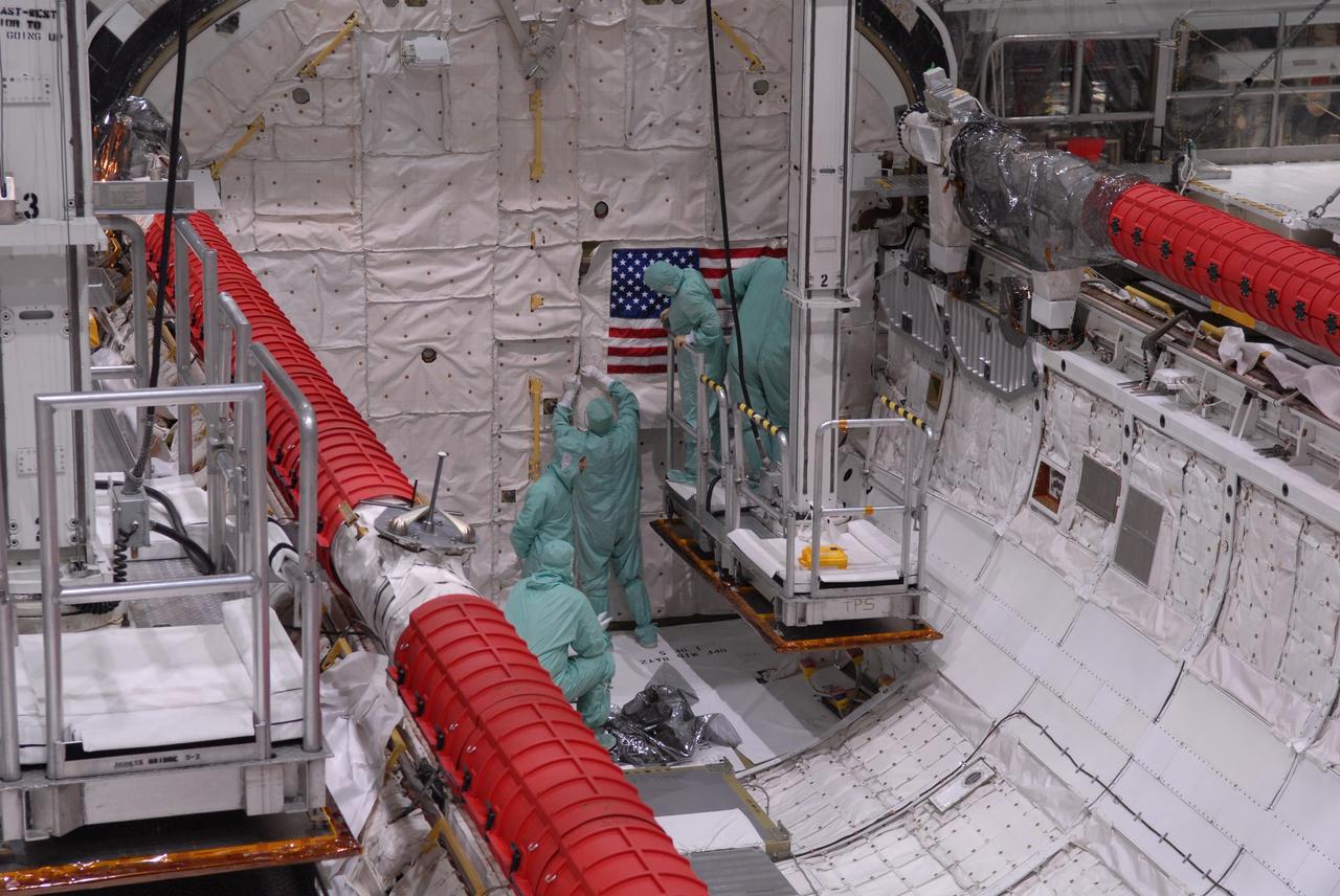 CAPE CANAVERAL, Fla. – Inside Orbiter Processing Facility 2 at NASA's Kennedy Space Center, United Space Alliance technicians secure the U.S. flag in space shuttle Endeavour's payload bay during processing.  Endeavour will deliver a multi-purpose logistics module to the International Space Station on its STS-126 mission. Launch is targeted for Nov. 10.  Photo credit: NASA/Amanda Diller