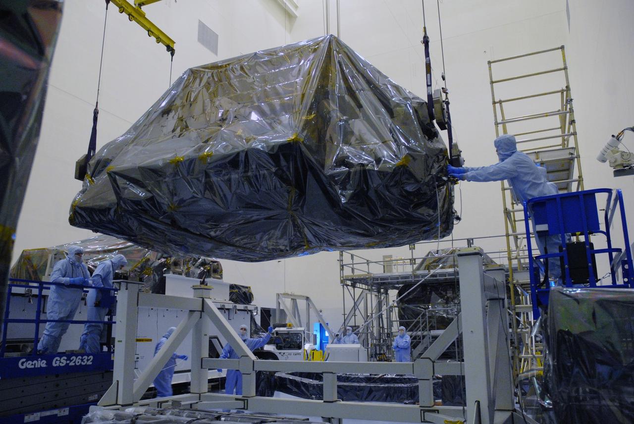 CAPE CANAVERAL, Fla. – In the high bay of the Payload Hazardous Servicing Facility at NASA's Kennedy Space Center, the Flight Support System for the Hubble Space Telescope is lowered onto a work platform by  workers from NASA's Goddard Space Flight Center. The Flight Support System, or FSS, is one of four carriers supporting hardware for space shuttle Atlantis' STS-125 mission to service the telescope. The Super Lightweight Interchangeable Carrier, or SLIC, and the Orbital Replacement Unit Carrier, or ORUC, have also arrived at Kennedy. The Multi-Use Lightweight Equipment carrier will be delivered in late July. The carriers will be prepared for the integration of telescope science instruments, both internal and external replacement components, as well as the flight support equipment to be used by the astronauts during the Hubble servicing mission, targeted for launch Oct. 8. Photo credit: NASA/Jack Pfaller