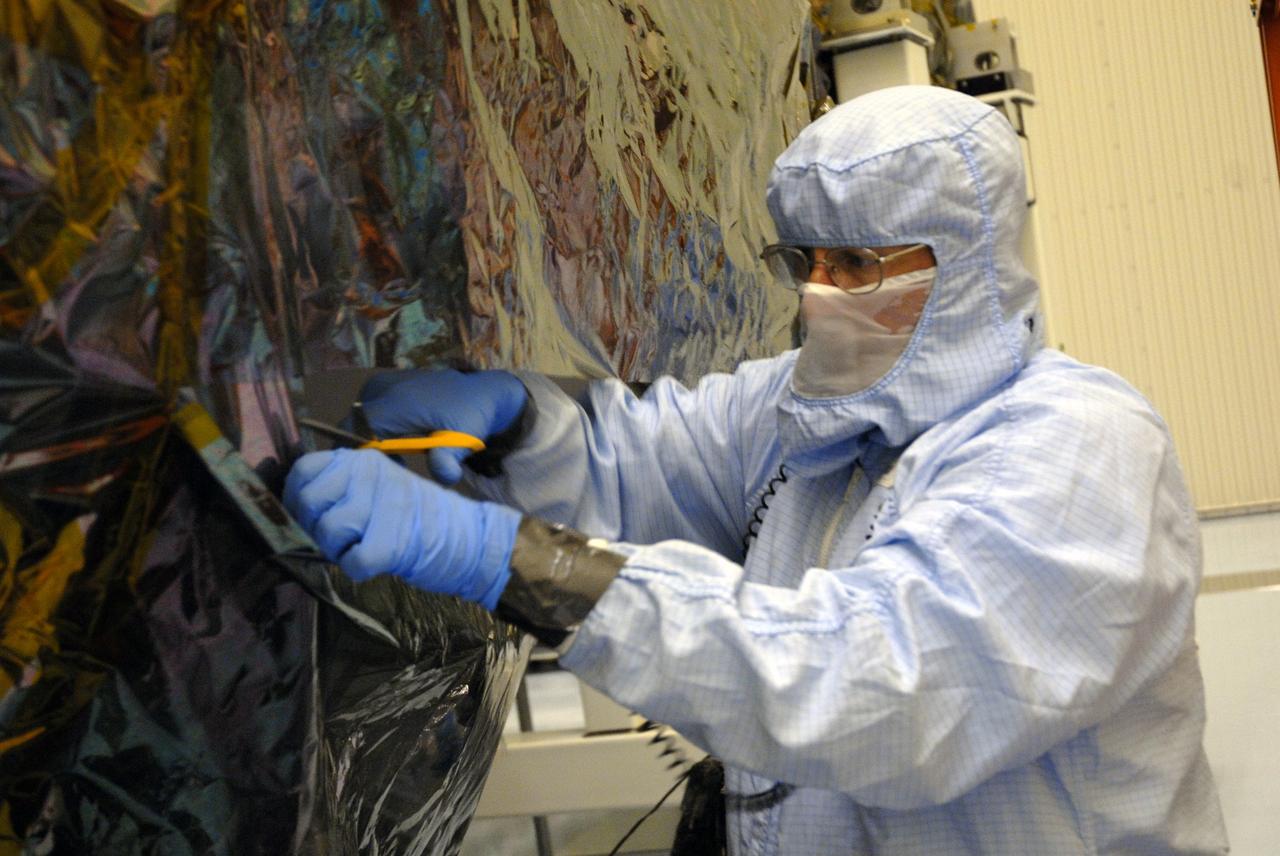 CAPE CANAVERAL, Fla. – In the high bay of the Payload Hazardous Servicing Facility at NASA's Kennedy Space Center, a worker from NASA's Goddard Space Flight Center cuts away the protective wrapping from the Orbital Replacement Unit Carrier for the Hubble Space Telescope. The Orbital Replacement Unit Carrier, or ORUC, is one of four carriers supporting hardware for space shuttle Atlantis' STS-125 mission to service the telescope. The Super Lightweight Interchangeable Carrier, or SLIC, and the Flight Support System, or FSS, have also arrived at Kennedy. The Multi-Use Lightweight Equipment carrier will be delivered in late July. The carriers will be prepared for the integration of telescope science instruments, both internal and external replacement components, as well as the flight support equipment to be used by the astronauts during the Hubble servicing mission, targeted for launch Oct. 8. Photo credit: NASA/Jack Pfaller