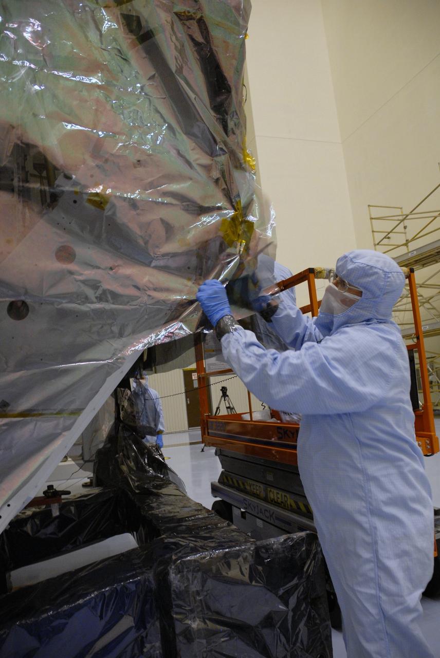 CAPE CANAVERAL, Fla. – In the high bay of the Payload Hazardous Servicing Facility at NASA's Kennedy Space Center, a worker from NASA's Goddard Space Flight Center cuts away the protective wrapping from the Orbital Replacement Unit Carrier for the Hubble Space Telescope.  The Orbital Replacement Unit Carrier, or ORUC, is one of four carriers supporting hardware for space shuttle Atlantis' STS-125 mission to service the telescope. The Super Lightweight Interchangeable Carrier, or SLIC, and the Flight Support System, or FSS, have also arrived at Kennedy. The Multi-Use Lightweight Equipment carrier will be delivered in late July. The carriers will be prepared for the integration of telescope science instruments, both internal and external replacement components, as well as the flight support equipment to be used by the astronauts during the Hubble servicing mission, targeted for launch Oct. 8. Photo credit: NASA/Jack Pfaller