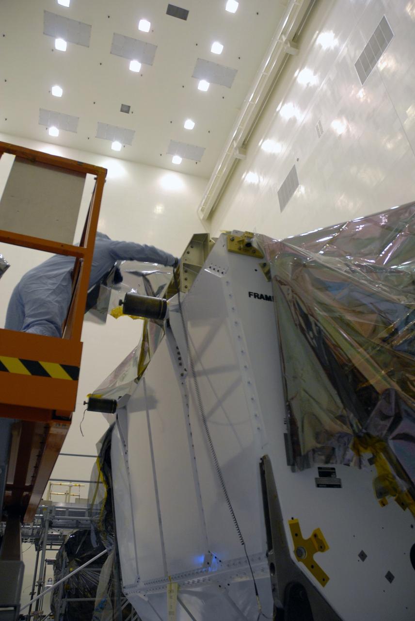 CAPE CANAVERAL, Fla. – In the high bay of the Payload Hazardous Servicing Facility at NASA's Kennedy Space Center, a worker from NASA's Goddard Space Flight Center removes the protective wrapping from the Orbital Replacement Unit Carrier for the Hubble Space Telescope.  The Orbital Replacement Unit Carrier, or ORUC, is one of four carriers supporting hardware for space shuttle Atlantis' STS-125 mission to service the telescope. The Super Lightweight Interchangeable Carrier, or SLIC, and the Flight Support System, or FSS, have also arrived at Kennedy. The Multi-Use Lightweight Equipment carrier will be delivered in late July. The carriers will be prepared for the integration of telescope science instruments, both internal and external replacement components, as well as the flight support equipment to be used by the astronauts during the Hubble servicing mission, targeted for launch Oct. 8. Photo credit: NASA/Jack Pfaller