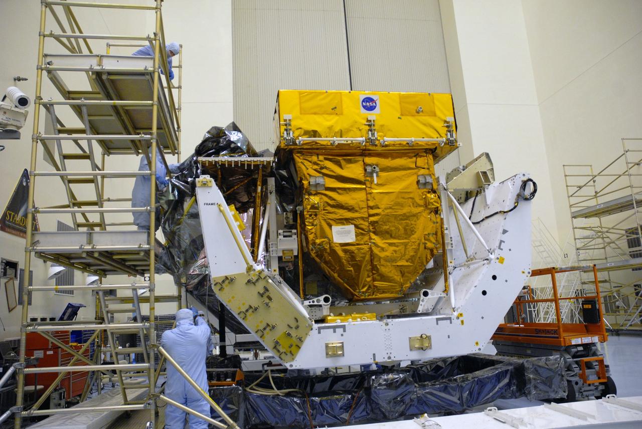 CAPE CANAVERAL, Fla. – In the high bay of the Payload Hazardous Servicing Facility at NASA's Kennedy Space Center, a worker from NASA's Goddard Space Flight Center removes the protective wrapping from the Orbital Replacement Unit Carrier for the Hubble Space Telescope.  The Orbital Replacement Unit Carrier, or ORUC, is one of four carriers supporting hardware for space shuttle Atlantis' STS-125 mission to service the telescope. The Super Lightweight Interchangeable Carrier, or SLIC, and the Flight Support System, or FSS, have also arrived at Kennedy.  The Multi-Use Lightweight Equipment carrier will be delivered in late July. The carriers will be prepared for the integration of telescope science instruments, both internal and external replacement components, as well as the flight support equipment to be used by the astronauts during the Hubble servicing mission, targeted for launch Oct. 8. Photo credit: NASA/Jack Pfaller