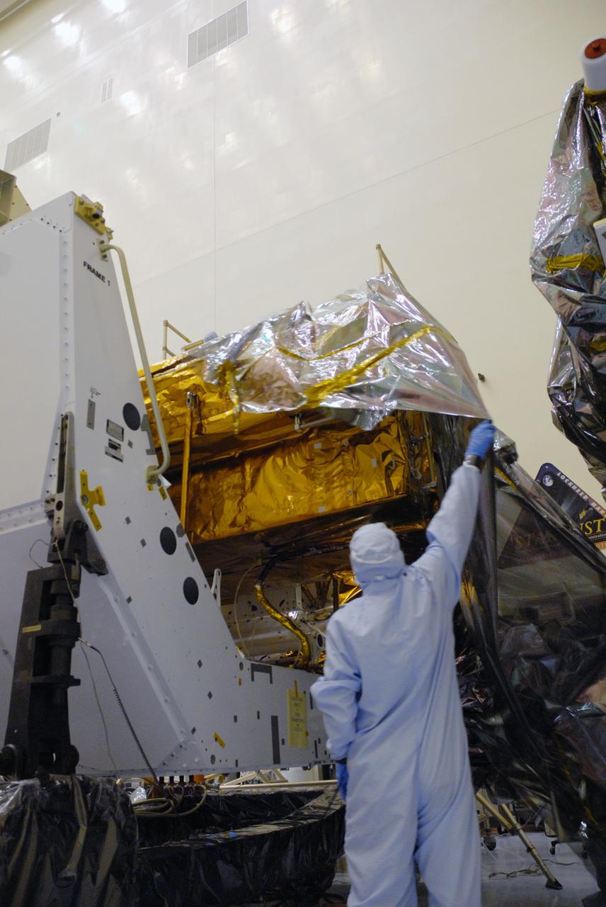 CAPE CANAVERAL, Fla. – In the high bay of the Payload Hazardous Servicing Facility at NASA's Kennedy Space Center, a worker from NASA's Goddard Space Flight Center removes the protective wrapping from the Orbital Replacement Unit Carrier for the Hubble Space Telescope.  The Orbital Replacement Unit Carrier, or ORUC, is one of four carriers supporting hardware for space shuttle Atlantis' STS-125 mission to service the telescope. The Super Lightweight Interchangeable Carrier, or SLIC, and the Flight Support System, or FSS, have also arrived at Kennedy. The Multi-Use Lightweight Equipment carrier will be delivered in late July. The carriers will be prepared for the integration of telescope science instruments, both internal and external replacement components, as well as the flight support equipment to be used by the astronauts during the Hubble servicing mission, targeted for launch Oct. 8. Photo credit: NASA/Jack Pfaller