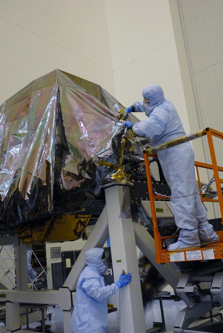 CAPE CANAVERAL, Fla. – In the high bay of the Payload Hazardous Servicing Facility at NASA's Kennedy Space Center, a worker from NASA's Goddard Space Flight Center cuts away the protective wrapping from the Super Lightweight Interchangeable Carrier for the Hubble Space Telescope.  The Super Lightweight Interchangeable Carrier, or SLIC, is one of four carriers supporting hardware for space shuttle Atlantis' STS-125 mission to service the telescope. The Orbital Replacement Unit Carrier, or ORUC, and the Flight Support System, or FSS, have also arrived at Kennedy. The Multi-Use Lightweight Equipment carrier will be delivered in late July. The carriers will be prepared for the integration of telescope science instruments, both internal and external replacement components, as well as the flight support equipment to be used by the astronauts during the Hubble servicing mission, targeted for launch Oct. 8. Photo credit: NASA/Jack Pfaller