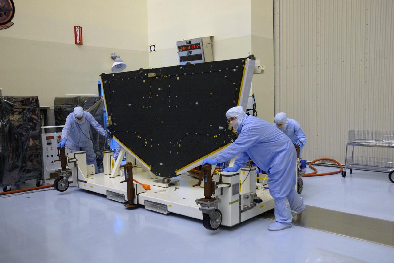 CAPE CANAVERAL, Fla. – In the high bay of the Payload Hazardous Servicing Facility at NASA's Kennedy Space Center, workers from NASA's Goddard Space Flight Center move the Hubble vertical platform toward the Super Lightweight Interchangeable Carrier for the Hubble Space Telescope, to which it will be mated.  The Super Lightweight Interchangeable Carrier, or SLIC, is one of four carriers supporting hardware for space shuttle Atlantis' STS-125 mission to service the telescope. SLIC is built with state-of-the-art, lightweight, composite materials - carbon fiber with a cyanate ester resin and a titanium metal matrix composite. These composites have greater strength-to-mass ratios than the metals typically used in spacecraft design. The Orbital Replacement Unit Carrier, or ORUC, and the Flight Support System, or FSS, have also arrived at Kennedy.     The Multi-Use Lightweight Equipment carrier will be delivered in early August. The carriers will be prepared for the integration of telescope science instruments, both internal and external replacement components, as well as the flight support equipment to be used by the astronauts during the Hubble servicing mission, targeted for launch Oct. 8.  Photo credit: NASA/Jack Pfaller
