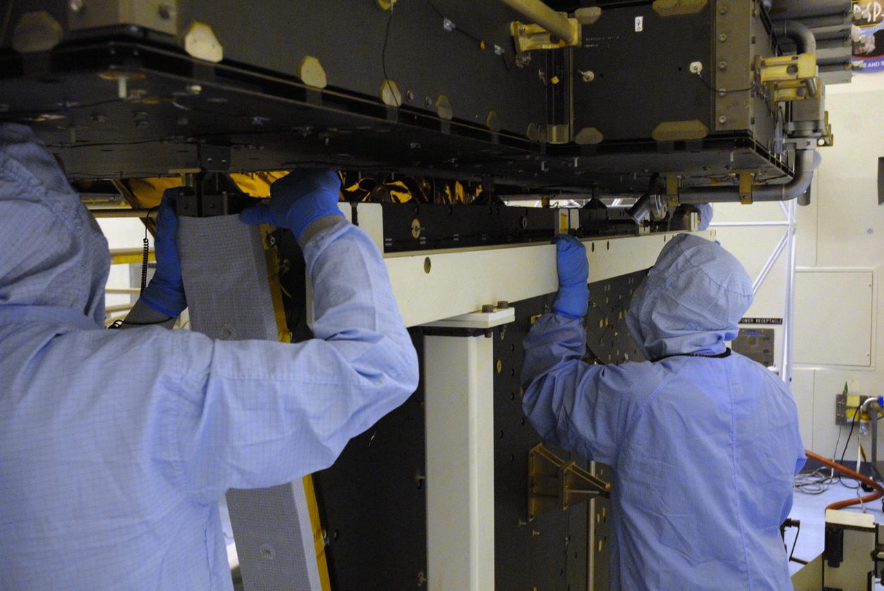 CAPE CANAVERAL, Fla. – In the high bay of the Payload Hazardous Servicing Facility at NASA's Kennedy Space Center, workers from NASA's Goddard Space Flight Center secure the Hubble vertical platform to the Super Lightweight Interchangeable Carrier for the Hubble Space Telescope.  The Super Lightweight Interchangeable Carrier, or SLIC, is one of four carriers supporting hardware for space shuttle Atlantis' STS-125 mission to service the telescope. SLIC is built with state-of-the-art, lightweight, composite materials - carbon fiber with a cyanate ester resin and a titanium metal matrix composite. These composites have greater strength-to-mass ratios than the metals typically used in spacecraft design. The Orbital Replacement Unit Carrier, or ORUC, and the Flight Support System, or FSS, have also arrived at Kennedy.    The Multi-Use Lightweight Equipment carrier will be delivered in early August. The carriers will be prepared for the integration of telescope science instruments, both internal and external replacement components, as well as the flight support equipment to be used by the astronauts during the Hubble servicing mission, targeted for launch Oct. 8.  Photo credit: NASA/Jack Pfaller