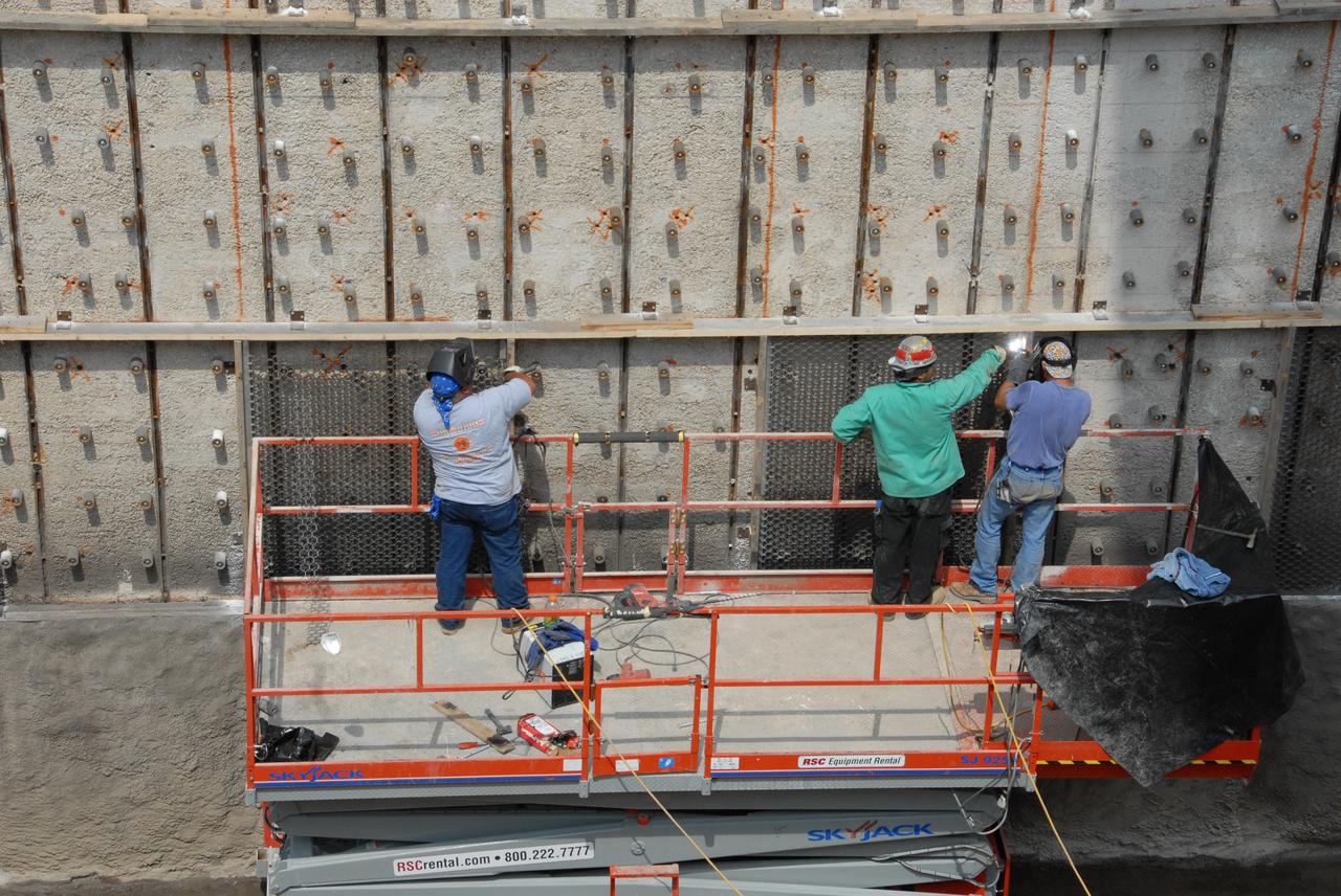 CAPE CANAVERAL, Fla. – Workers weld a steel grid structure to the wall of the flame trench on Launch Pad 39A at NASA's Kennedy Space Center. Damage to the trench occurred during the launch of Discovery on the STS-124 mission. A 75- by 20-foot section of the east wall was destroyed and debris scattered as far as the pad perimeter fence. Repairs are expected to be completed before the targeted Oct. 8 launch of Atlantis on the NASA Hubble Space Telescope servicing mission. Photo credit: NASA/Jack Pfaller