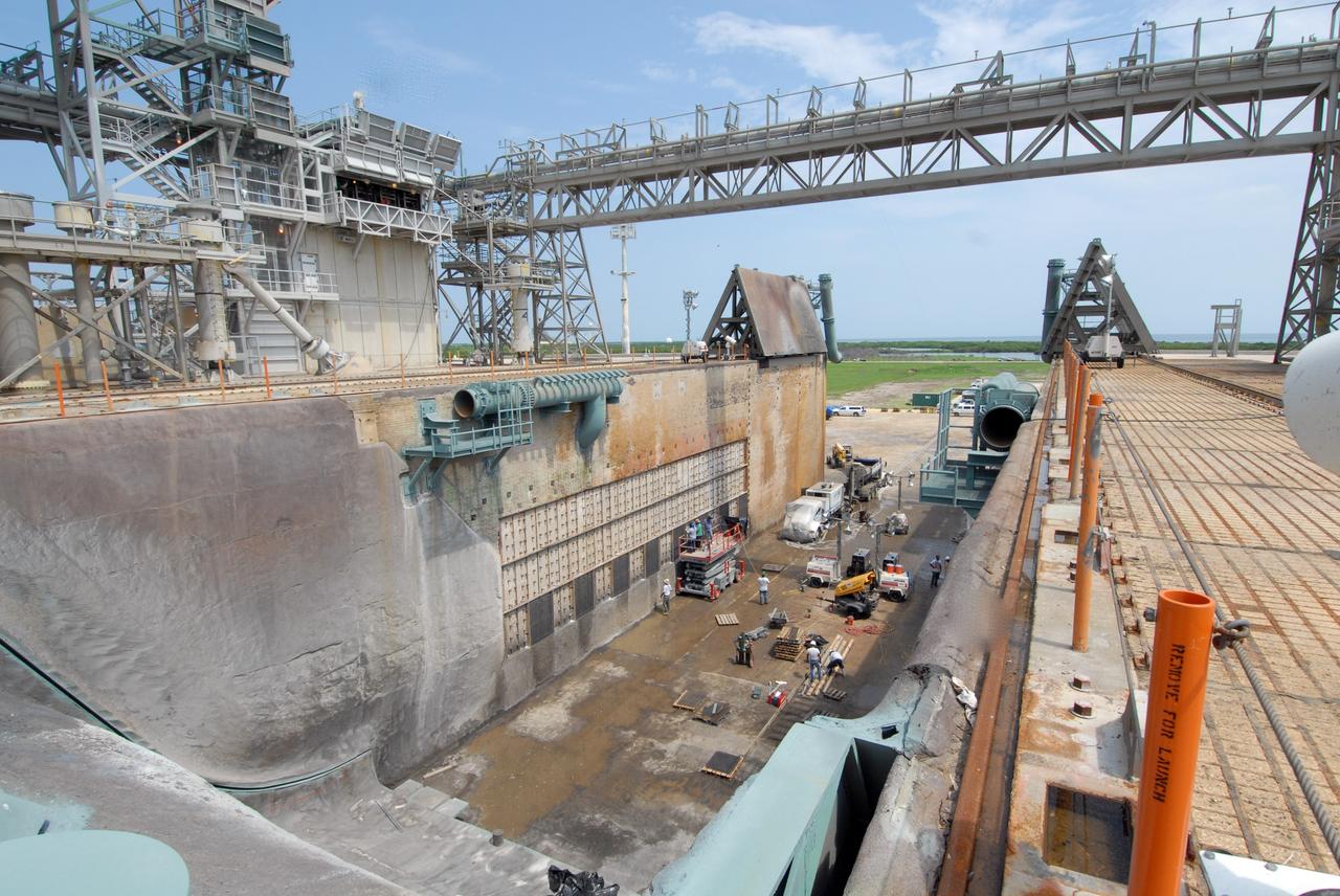 CAPE CANAVERAL, Fla. – This elevated view shows workers on a platform welding a steel grid structure to the wall of the flame trench on Launch Pad 39A at NASA's Kennedy Space Center. Damage to the trench occurred during the launch of Discovery on the STS-124 mission. A 75- by 20-foot section of the east wall was destroyed and debris scattered as far as the pad perimeter fence. Repairs are expected to be completed before the targeted Oct. 8 launch of Atlantis on the NASA Hubble Space Telescope servicing mission. Photo credit: NASA/Jack Pfaller