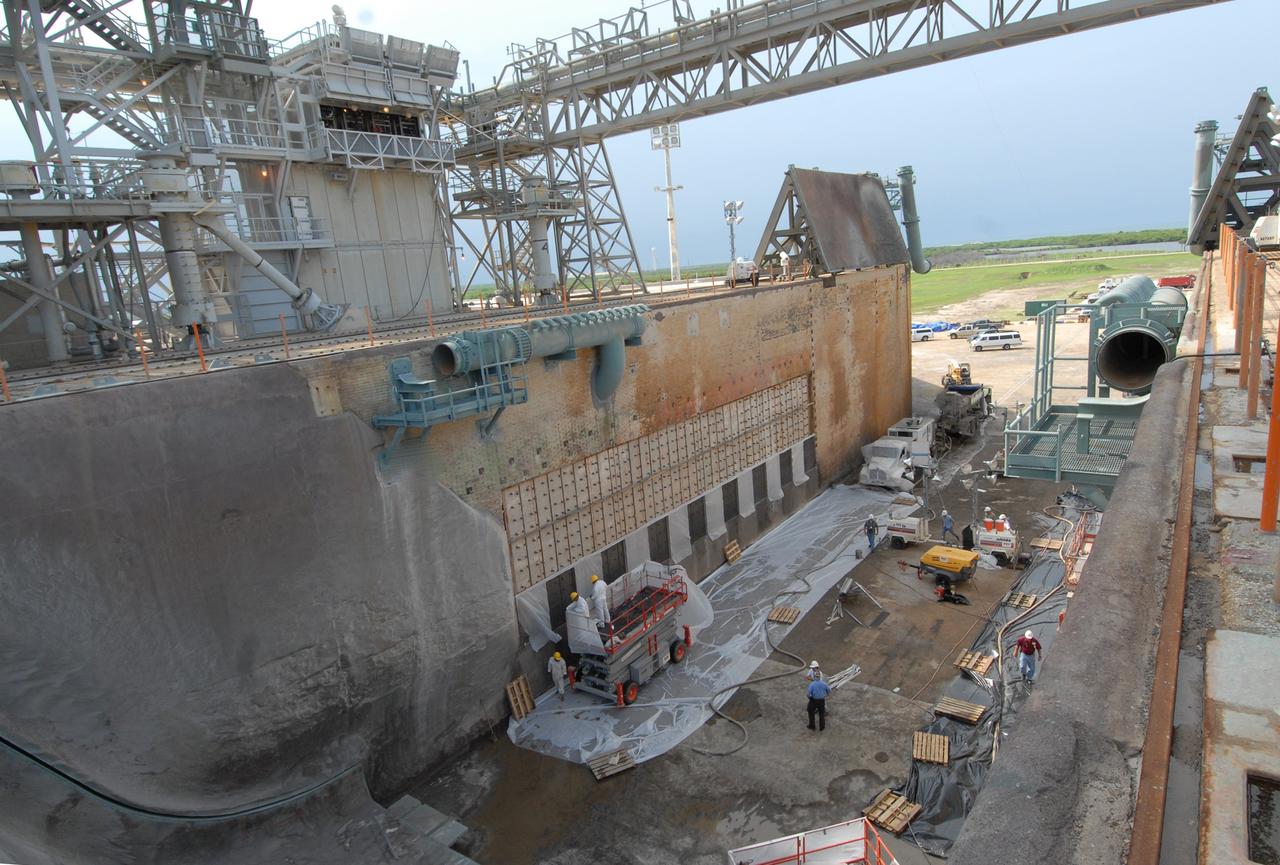 CAPE CANAVERAL, Fla. – This elevated view of Launch Pad 39A at NASA's Kennedy Space Center shows workers preparing to fill steel grid structures, welded to the wall of the flame trench, with a heat-resistant concrete called Fondue Fyre, developed during NASA's Apollo lunar program. Damage to the trench occurred during the May 31 launch of Discovery on the STS-124 mission. A 75- by 20-foot section of the east wall was destroyed and debris scattered as far as the pad perimeter fence. Repairs are expected to be completed before the targeted Oct. 8 launch of Atlantis on the NASA Hubble Space Telescope servicing mission. Photo credit: NASA/Jack Pfaller