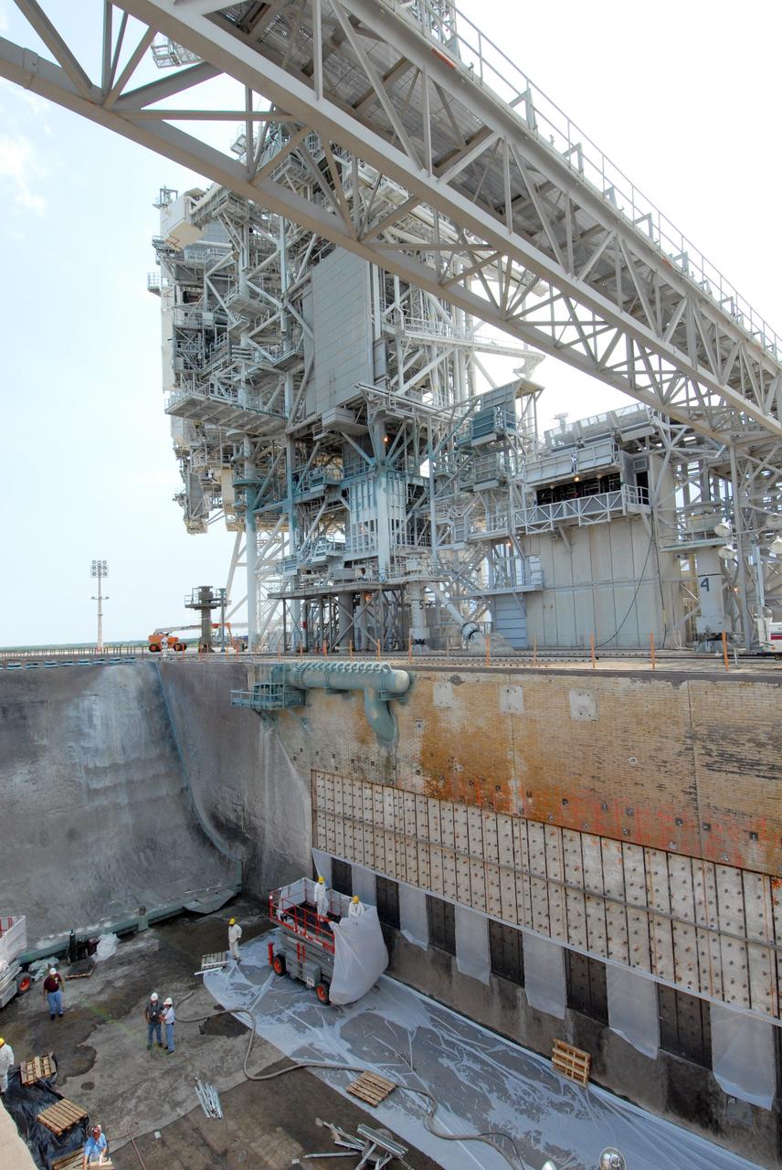 CAPE CANAVERAL, Fla. – This elevated view of Launch Pad 39A at NASA's Kennedy Space Center shows workers preparing to fill steel grid structures, welded to the wall of the flame trench, with a heat-resistant concrete called Fondue Fyre, developed during NASA's Apollo lunar program. Damage to the trench occurred during the May 31 launch of Discovery on the STS-124 mission. A 75- by 20-foot section of the east wall was destroyed and debris scattered as far as the pad perimeter fence. Repairs are expected to be completed before the targeted Oct. 8 launch of Atlantis on the NASA Hubble Space Telescope servicing mission. Photo credit: NASA/Jack Pfaller