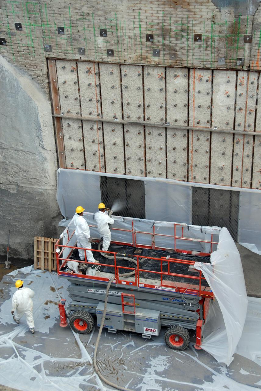 CAPE CANAVERAL, Fla. – This elevated view of Launch Pad 39A at NASA's Kennedy Space Center shows workers filling steel grid structures, welded to the wall of the flame trench, with a heat-resistant concrete called Fondue Fyre, developed during NASA's Apollo lunar program. Damage to the trench occurred during the May 31 launch of Discovery on the STS-124 mission. A 75- by 20-foot section of the east wall was destroyed and debris scattered as far as the pad perimeter fence. Repairs are expected to be completed before the targeted Oct. 8 launch of Atlantis on the NASA Hubble Space Telescope servicing mission. Photo credit: NASA/Jack Pfaller