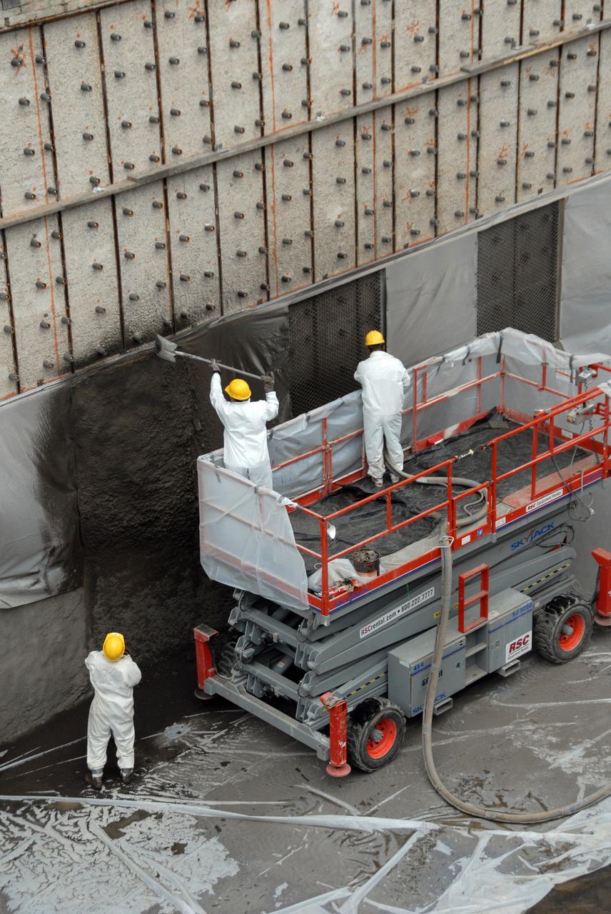 CAPE CANAVERAL, Fla. – At Launch Pad 39A at NASA's Kennedy Space Center, workers pack a heat-resistant concrete called Fondue Fyre into steel grid structures, welded to the wall of the flame trench. Fondue Fyre was developed during NASA's Apollo lunar program. Damage to the trench occurred during the May 31 launch of Discovery on the STS-124 mission. A 75- by 20-foot section of the east wall was destroyed and debris scattered as far as the pad perimeter fence. Repairs are expected to be completed before the targeted Oct. 8 launch of Atlantis on the NASA Hubble Space Telescope servicing mission. Photo credit: NASA/Jack Pfaller