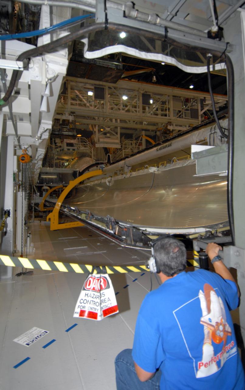 CAPE CANAVERAL, Fla. – In Orbiter Processing Facility 1 at NASA's Kennedy Space Center, a worker from United Space Alliance prepares to close the payload bay doors on space shuttle Atlantis. The payload bay has been thoroughly cleaned and is ready to receive the carriers transporting the instruments and equipment needed to service the Hubble Space Telescope.  Atlantis is targeted to launch Oct. 8 on the STS-125 mission to service Hubble. The mission crew will perform history-making, on-orbit “surgery” on two important science instruments aboard the telescope. After capturing the telescope, two teams of spacewalking astronauts will perform the repairs during five planned spacewalks. Photo credit: NASA/Jack Pfaller