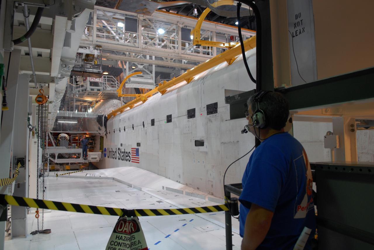 CAPE CANAVERAL, Fla. – In Orbiter Processing Facility 1 at NASA's Kennedy Space Center, a worker from United Space Alliance gives the signal that the payload bay doors on space shuttle Atlantis are closed. The payload bay has been thoroughly cleaned and is ready to receive the carriers transporting the instruments and equipment needed to service the Hubble Space Telescope.  Atlantis is targeted to launch Oct. 8 on the STS-125 mission to service Hubble. The mission crew will perform history-making, on-orbit “surgery” on two important science instruments aboard the telescope. After capturing the telescope, two teams of spacewalking astronauts will perform the repairs during five planned spacewalks. Photo credit: NASA/Jack Pfaller